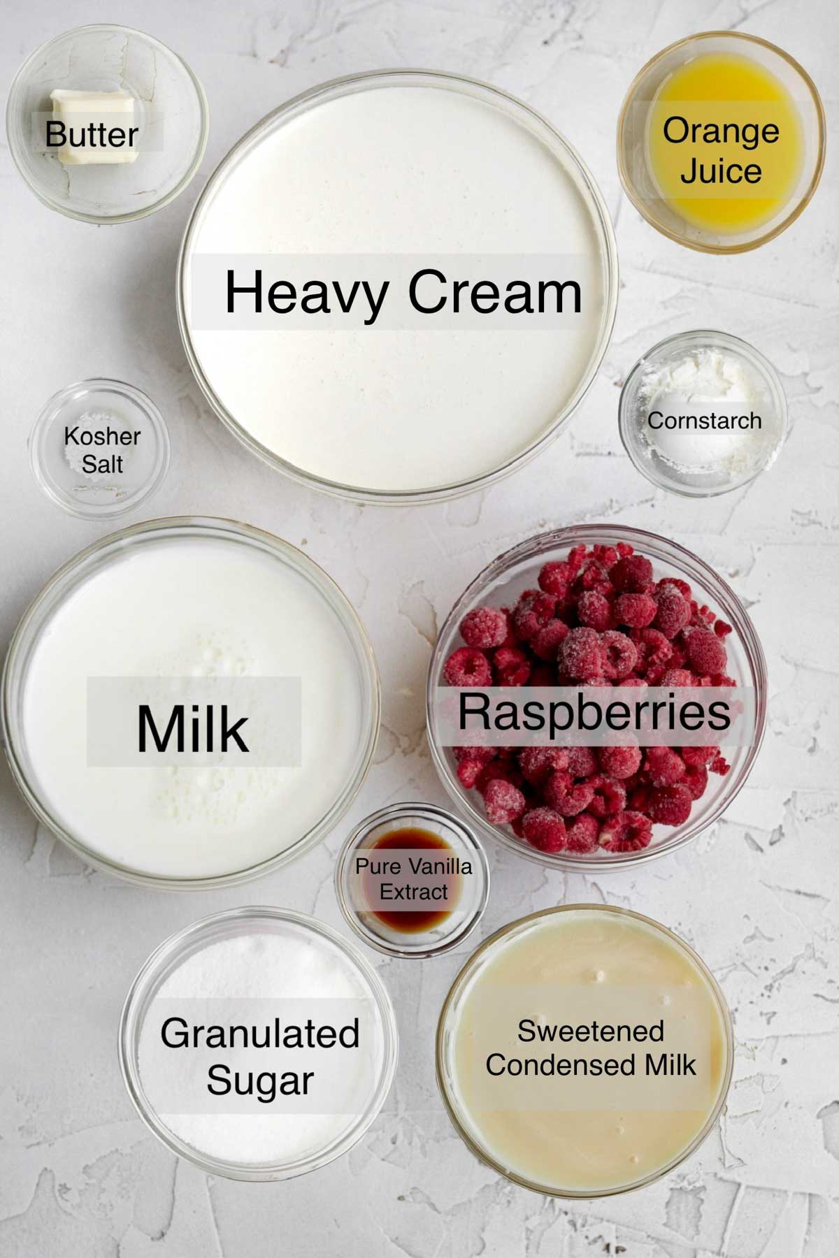 raspberry ripple ice cream ingredients in separate containers: butter, heavy cream, orange juice, kosher salt, cornstarch, milk, frozen raspberries, pure vanilla extract, granulated sugar, and sweetened condensed milk.
