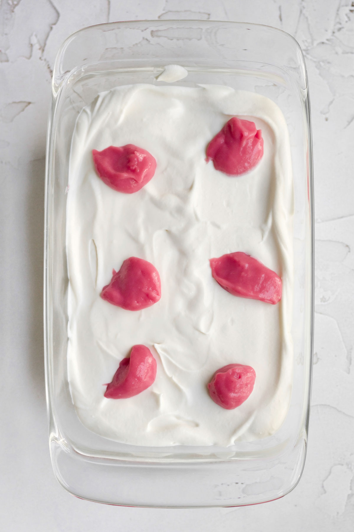 six dollops of vibrant raspberry curd spaced out in the vanilla ice cream base.