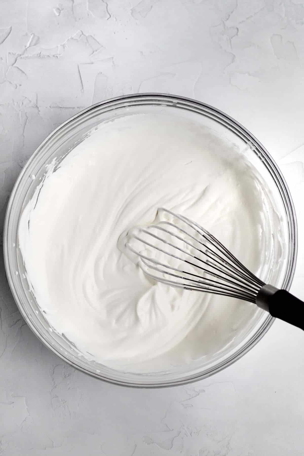 whipping the heavy cream until soft peaks form.