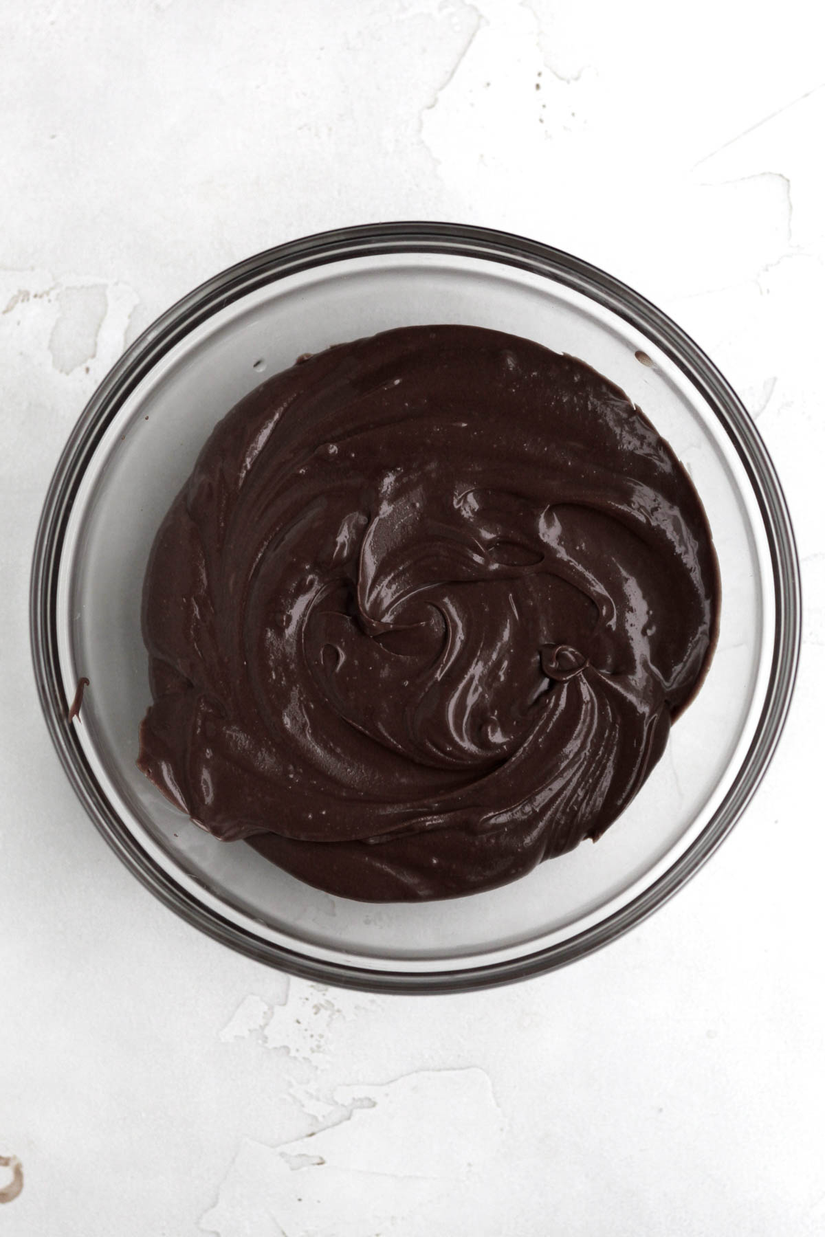 A bowl of dar and delicious chocolate cream cheese icing.