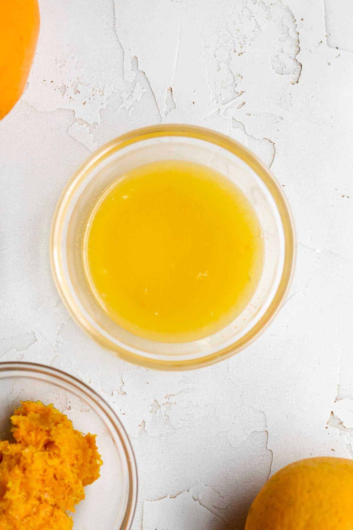 fresh orange juice and bright orange zest in bowls.
