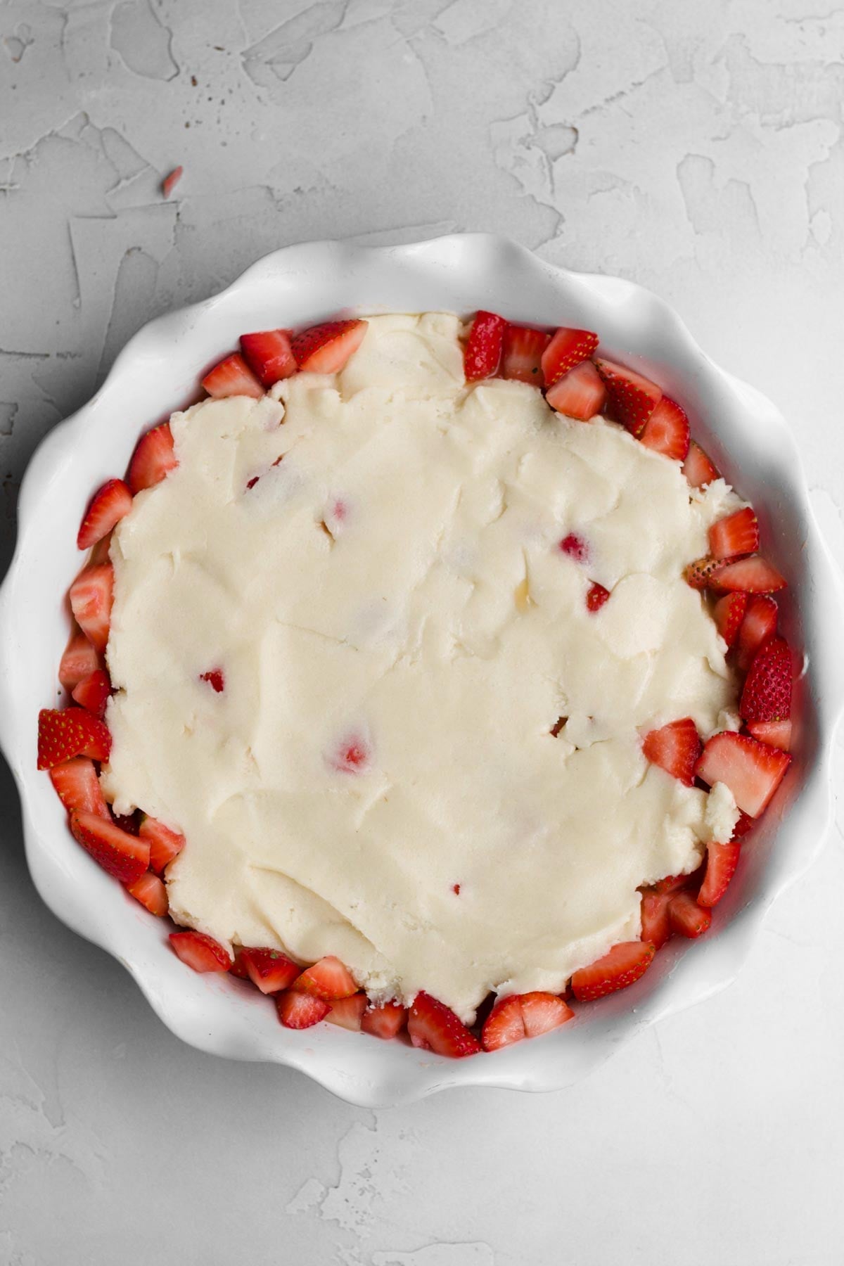 smoothing out the batter in the dish.
