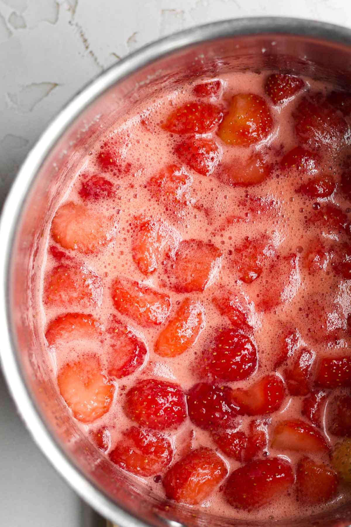 A saucepan with the boiling strawberry mixture.