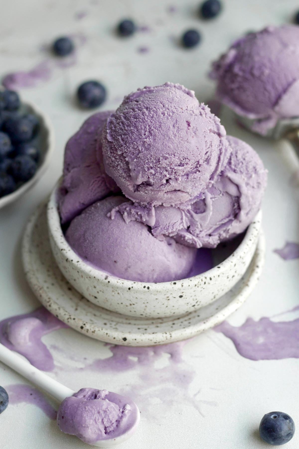 Scoops of delicious purple blueberry ice cream packed into a bowl.