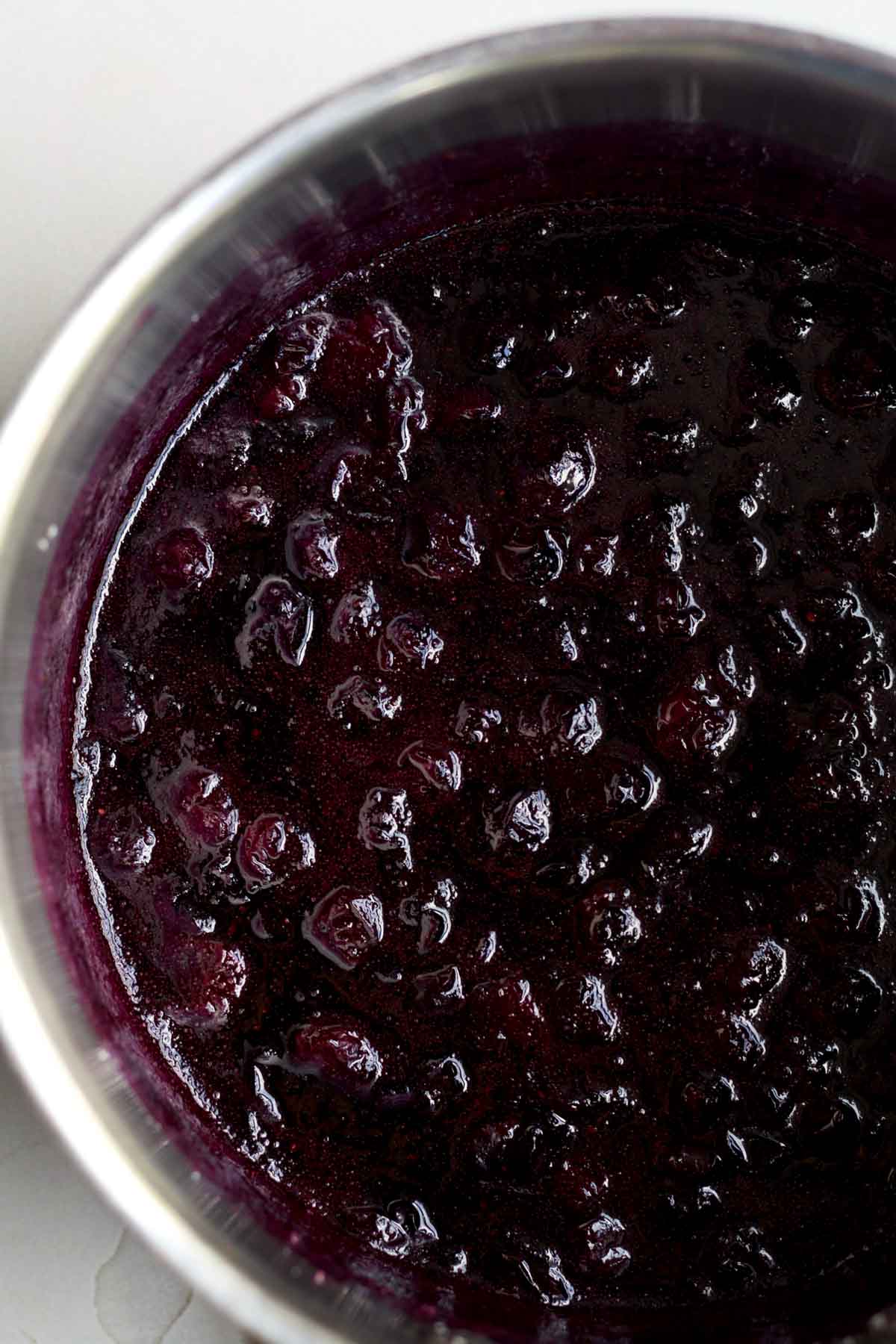 Warm, deep magenta blueberries in a saucepan.