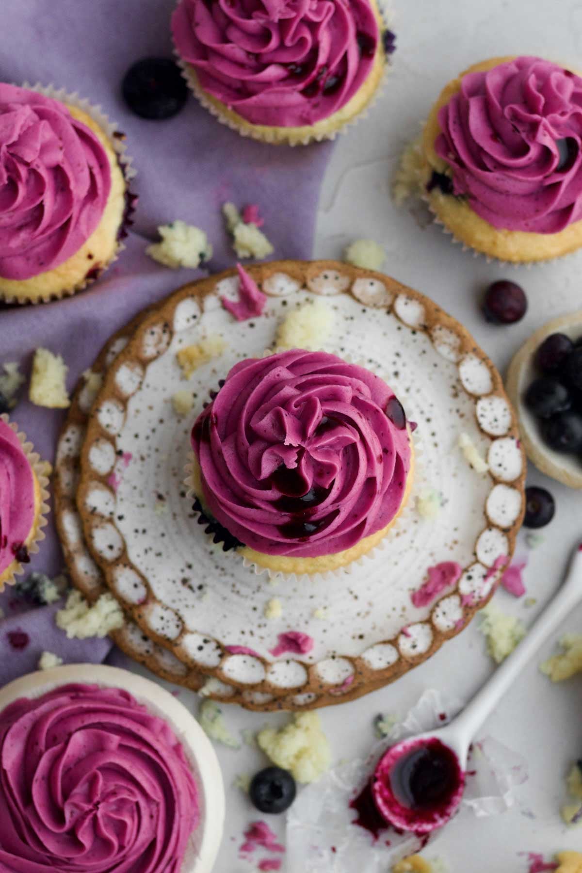 The tight magenta swirl of blueberry frosting with blueberry drizzle on the blueberry cupcakes.