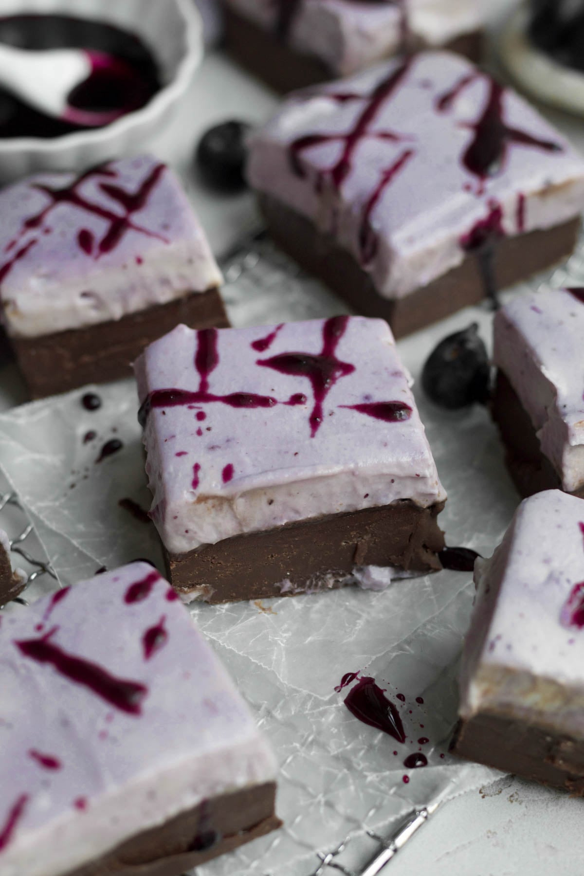 Square blueberry fudge bars with blueberry cream cheese topping and bright blueberry drizzle.
