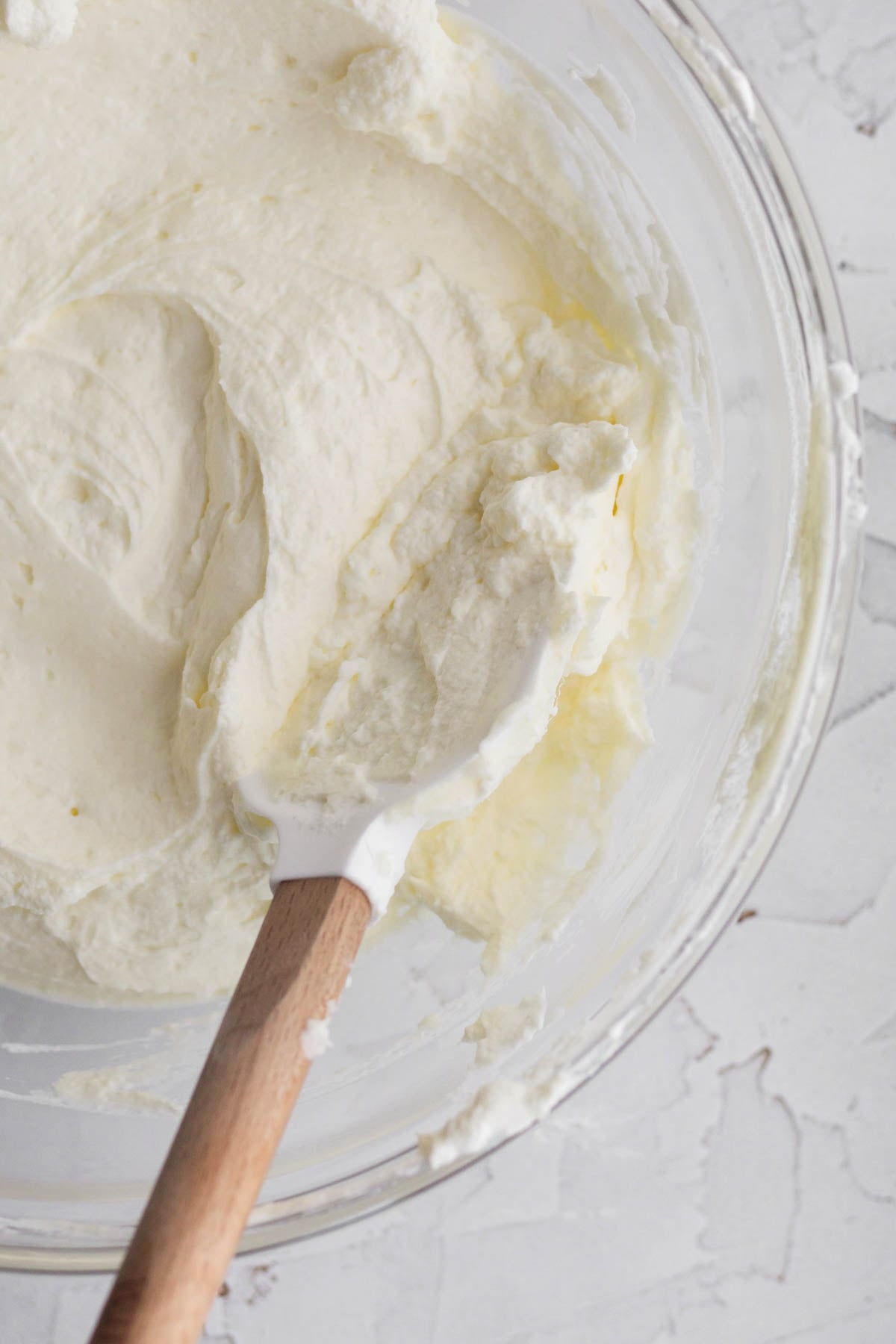 Mixing the cream cheese and whipped cream in a bowl.