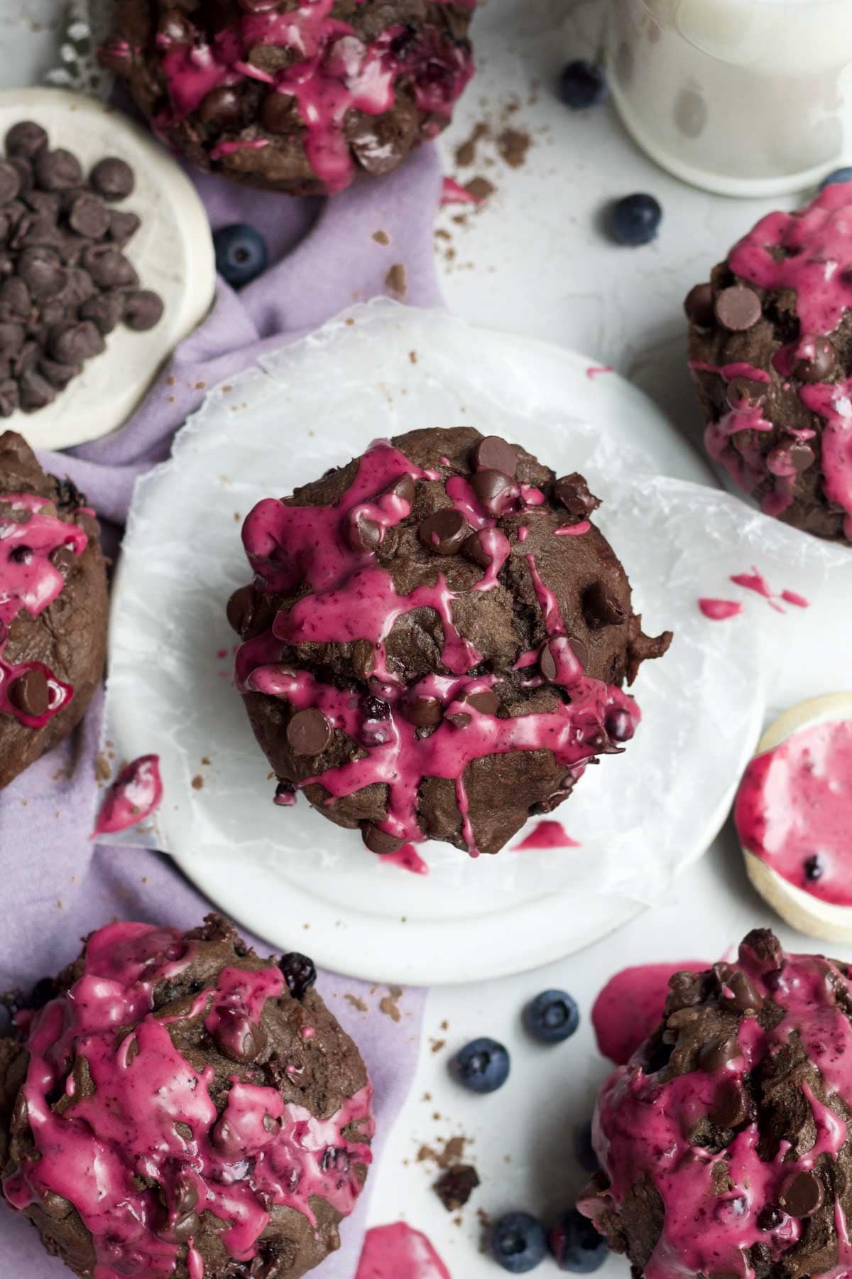Streaks of blueberry icing on the warm chocolate blueberry muffins with chocolate chips.