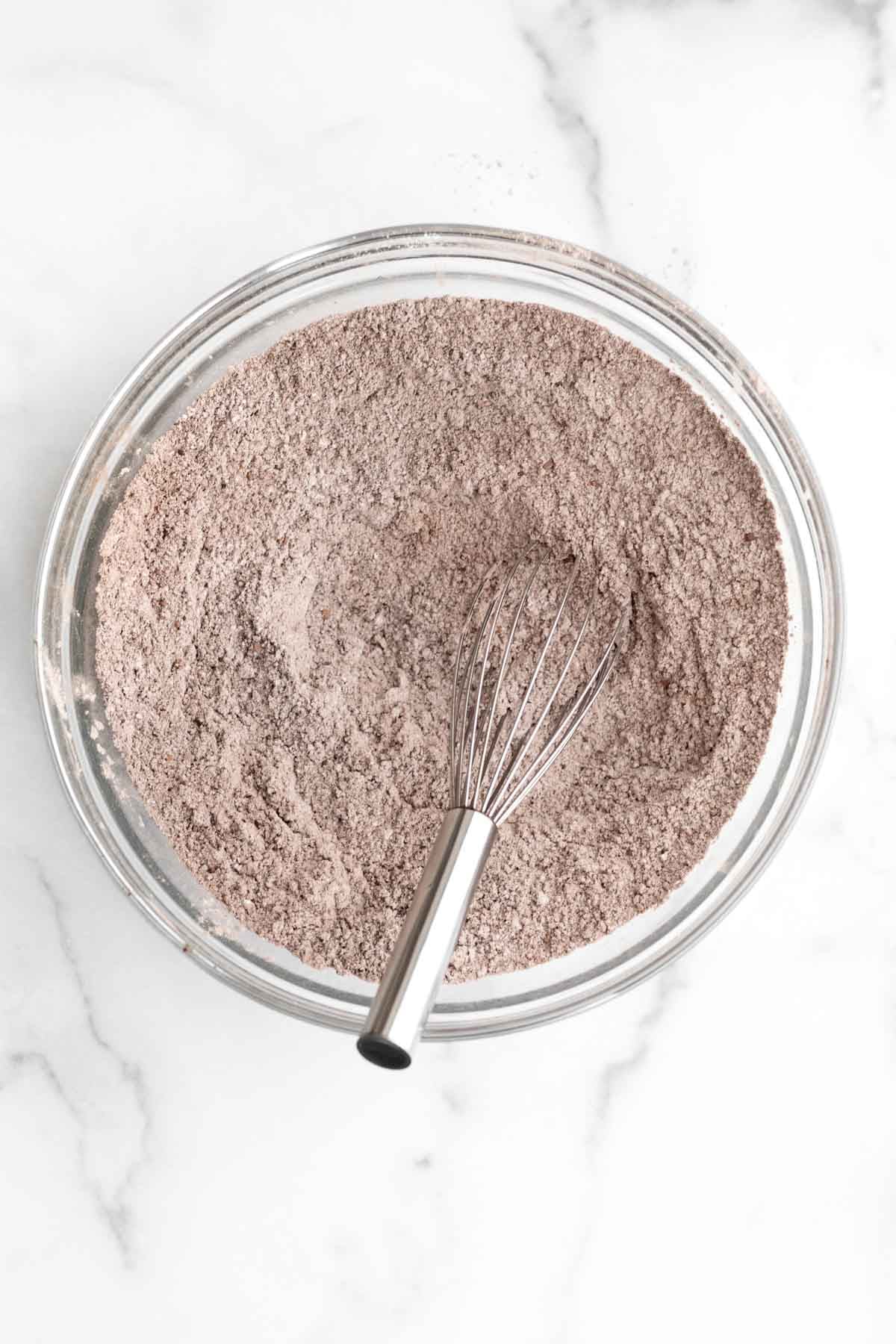 A whisk with the chocolatey dry ingredients.