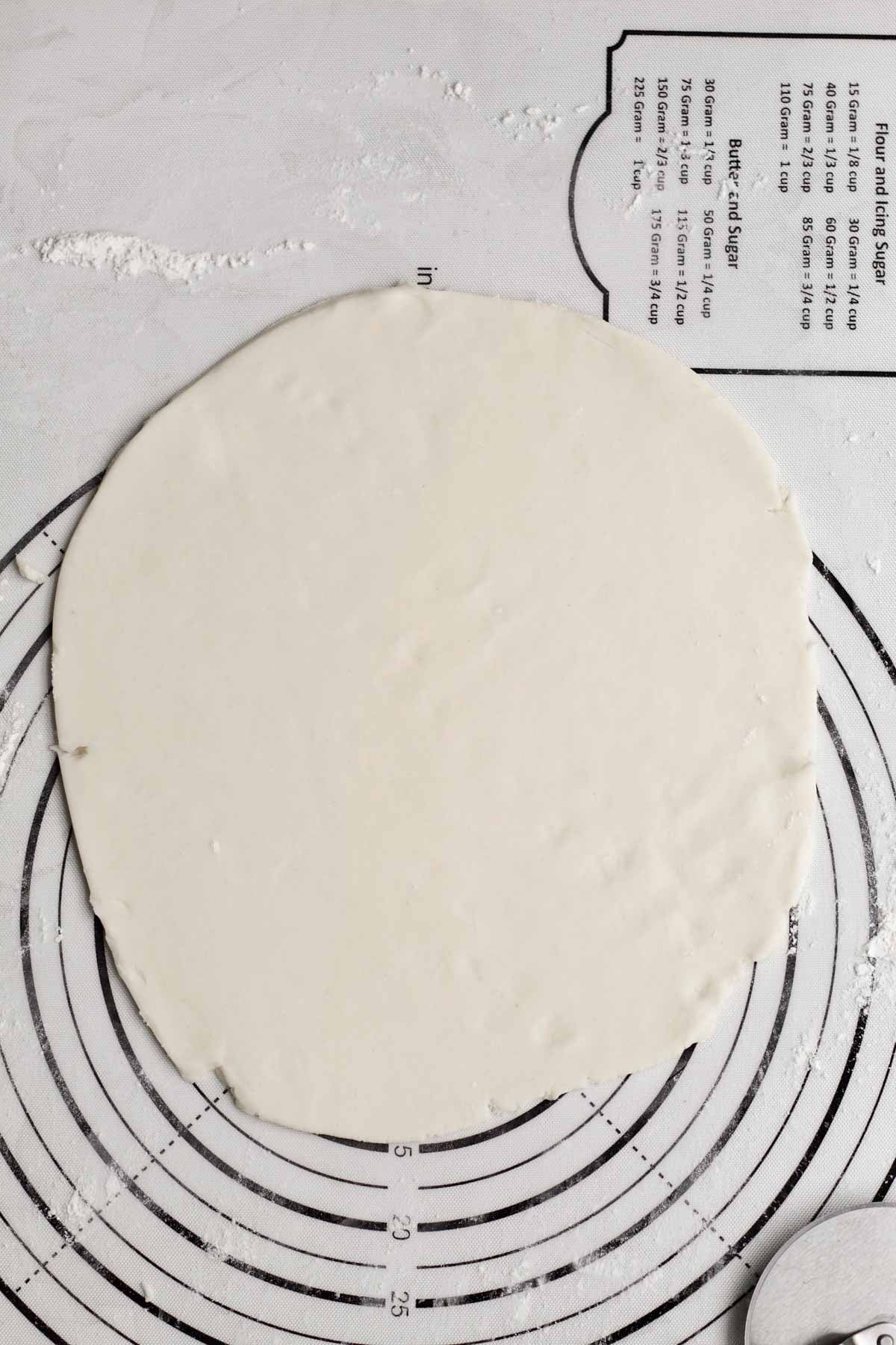 A disc of rolled-out flat puff pastry dough.