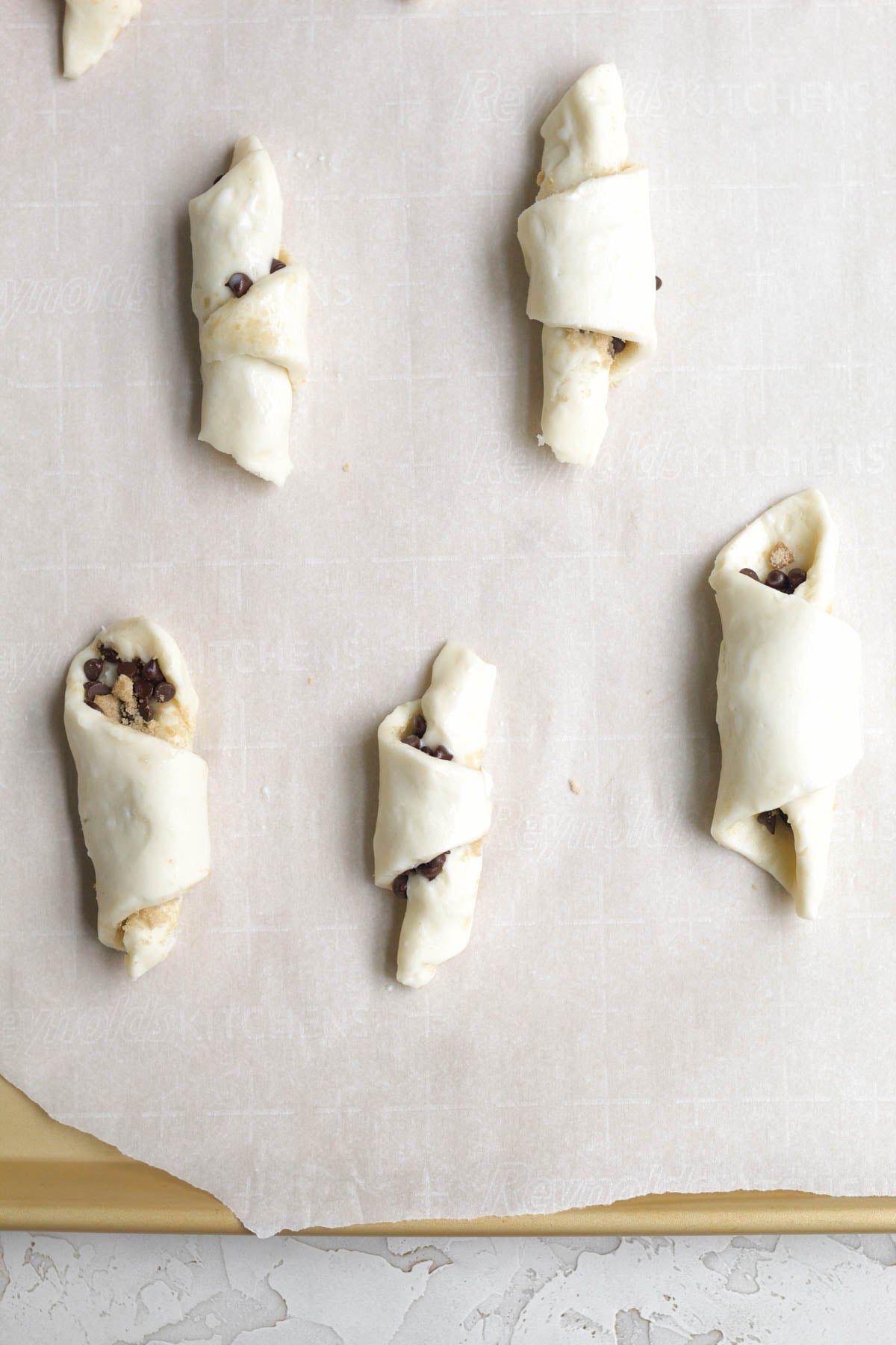 Twists brushed with butter on parchment ready to go in the oven.