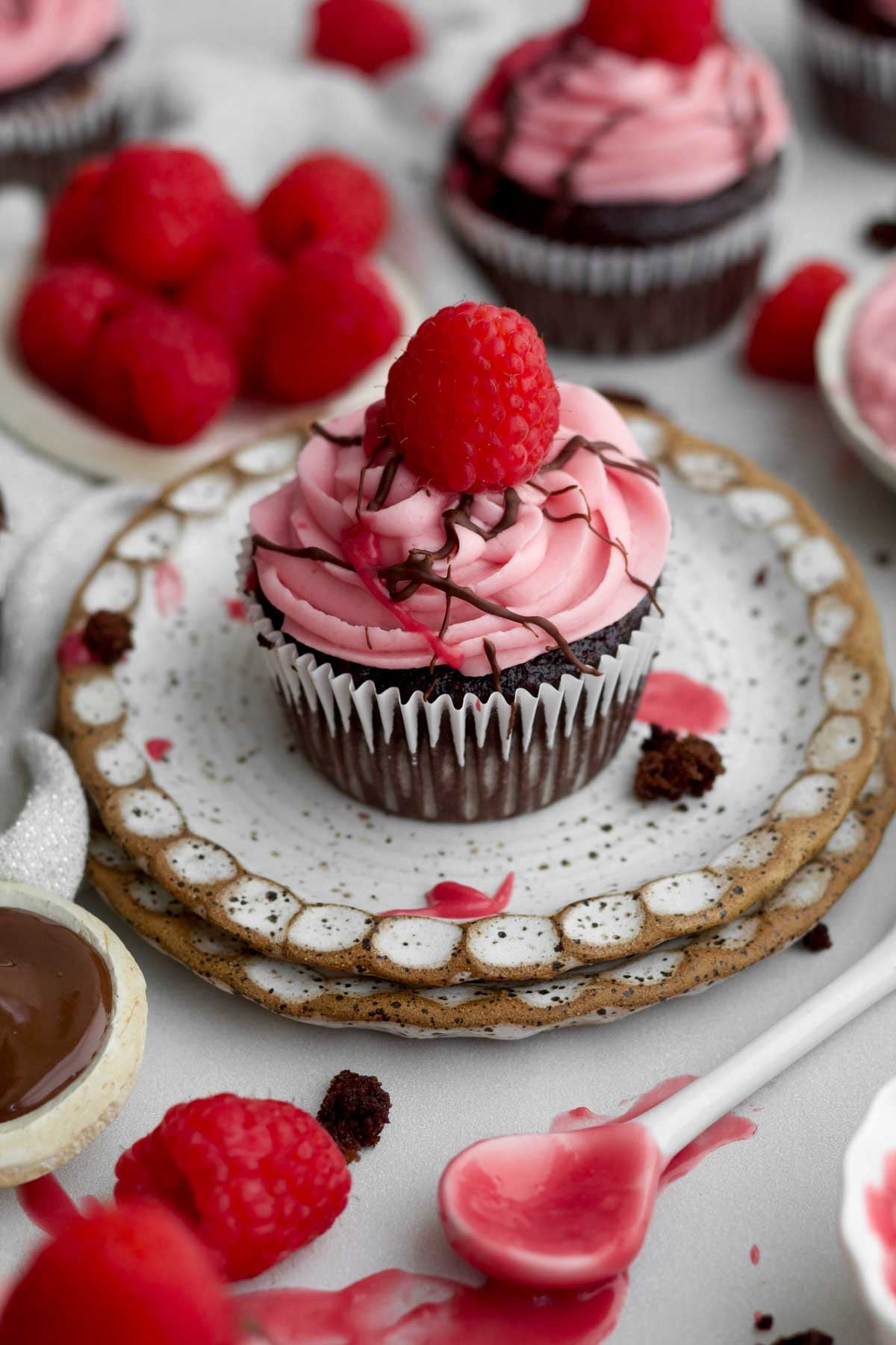 Gluten-free chocolate raspberry cupcake with creamy raspberry buttercream and topped with a fresh raspberry.