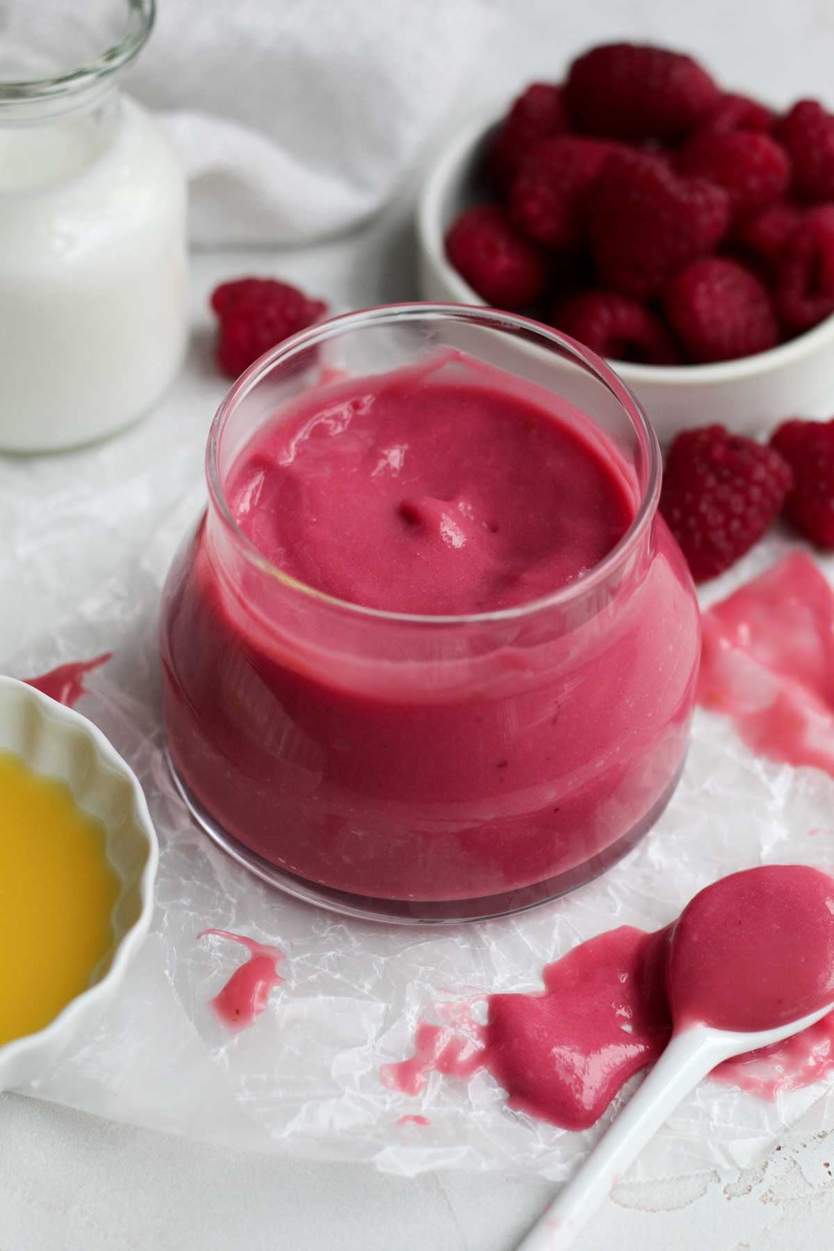 A glass jar or luscious pink raspberry curd.