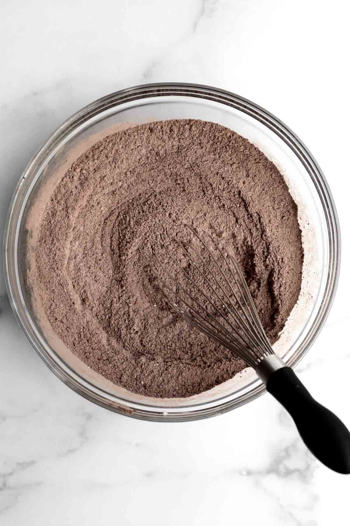 A whisk with the chocolatey dry ingredients.