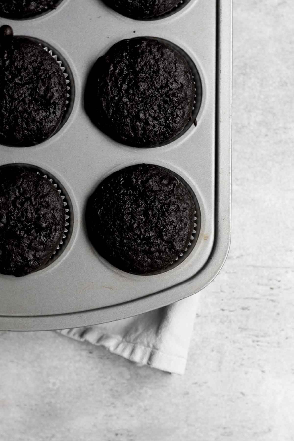 Risen chocolatey cupcake bases in the tin.