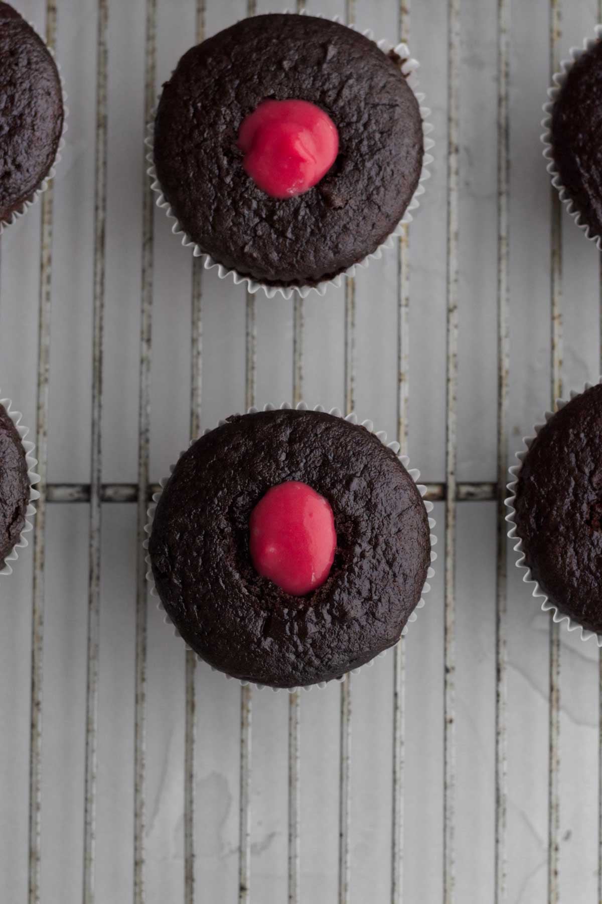 Filling the holes in the cupcakes with the raspberry curd.