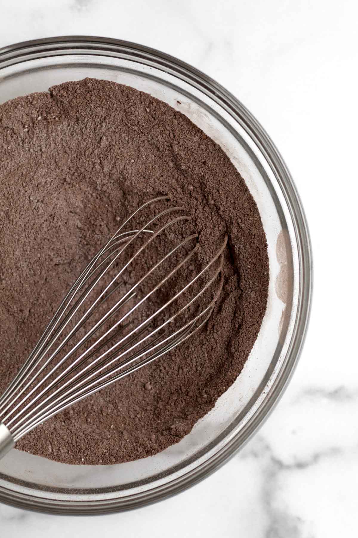 A whisk with the chocolatey dry ingredients.