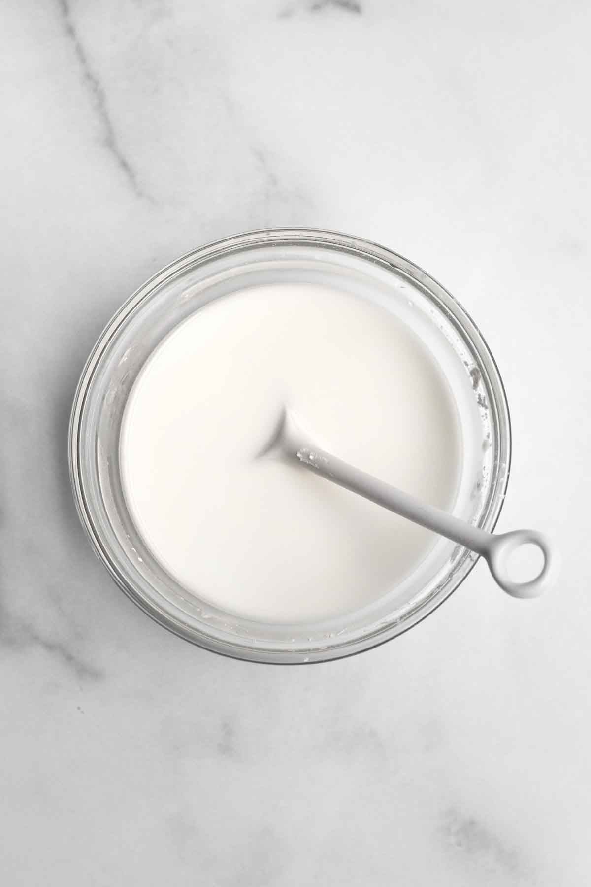 Milky white cornstarch water with a spoon.