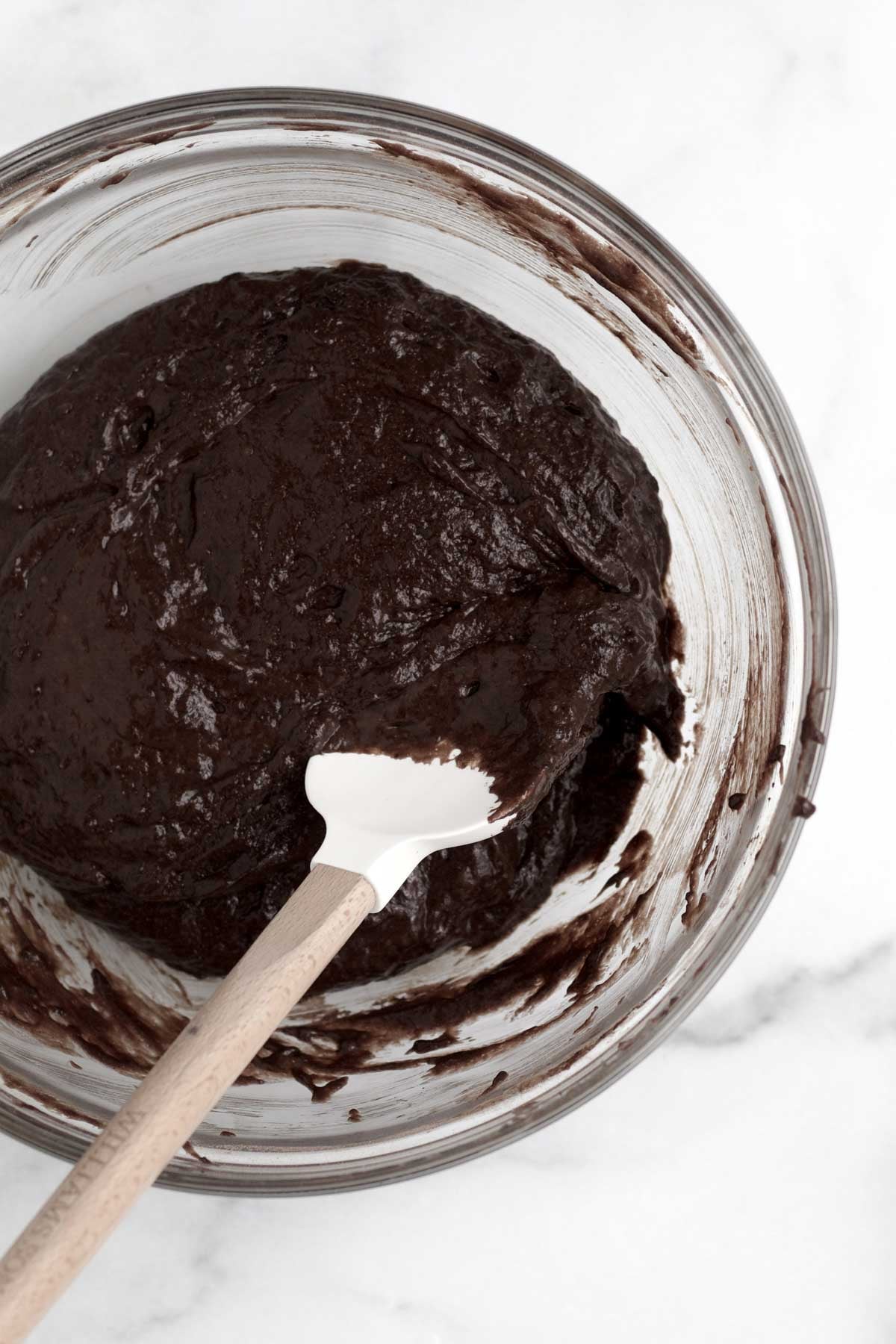 Mixing in the wet ingredients to make a chocolate waffle batter.