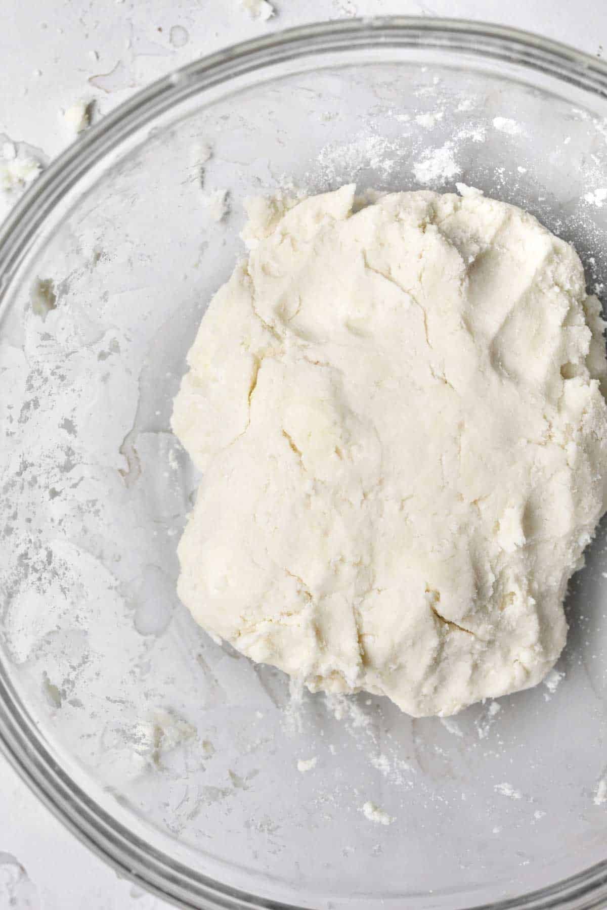 White pressed pastry dough in a clear bowl.