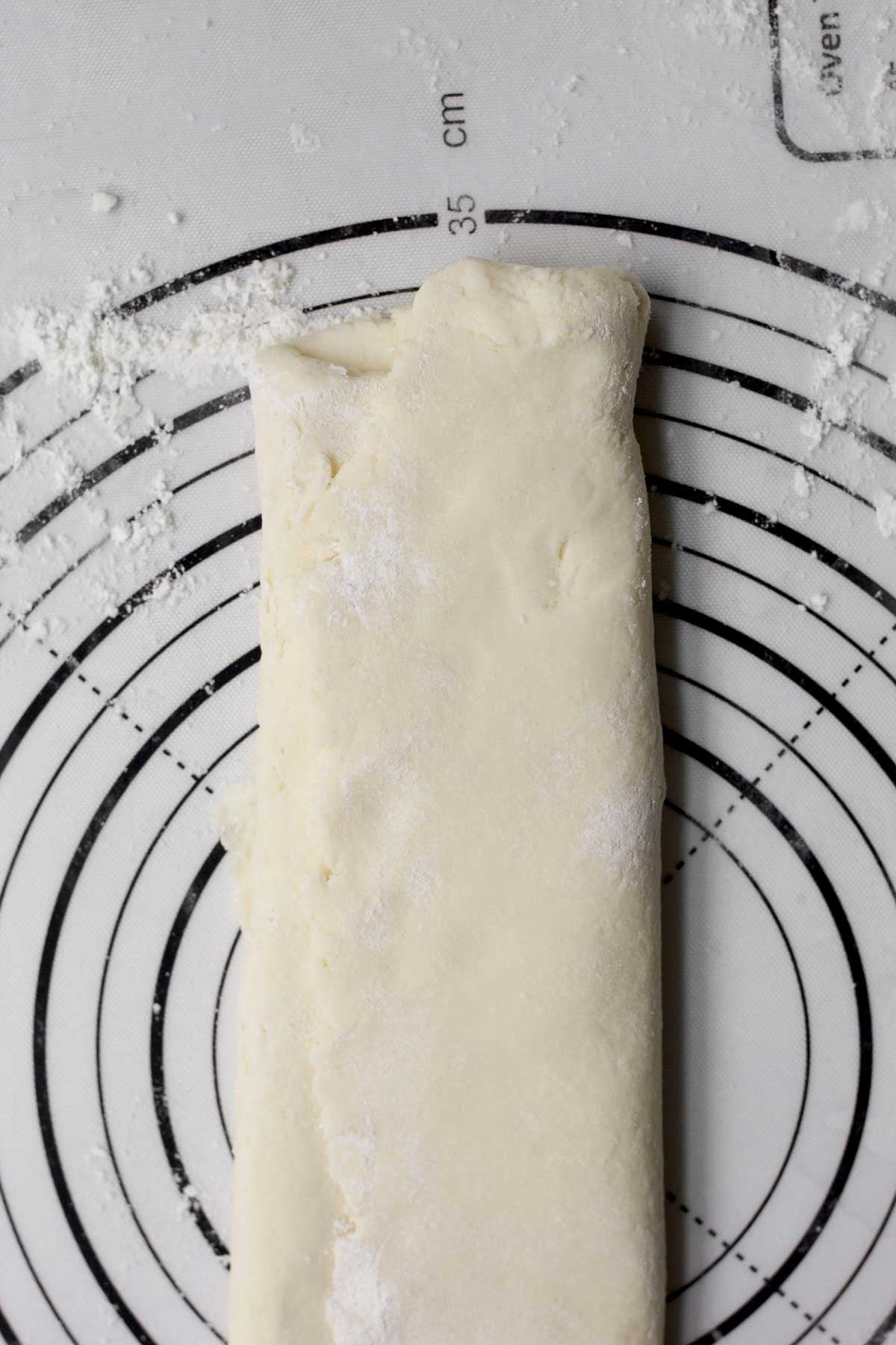 Folding the dough long-ways on the cutting board.