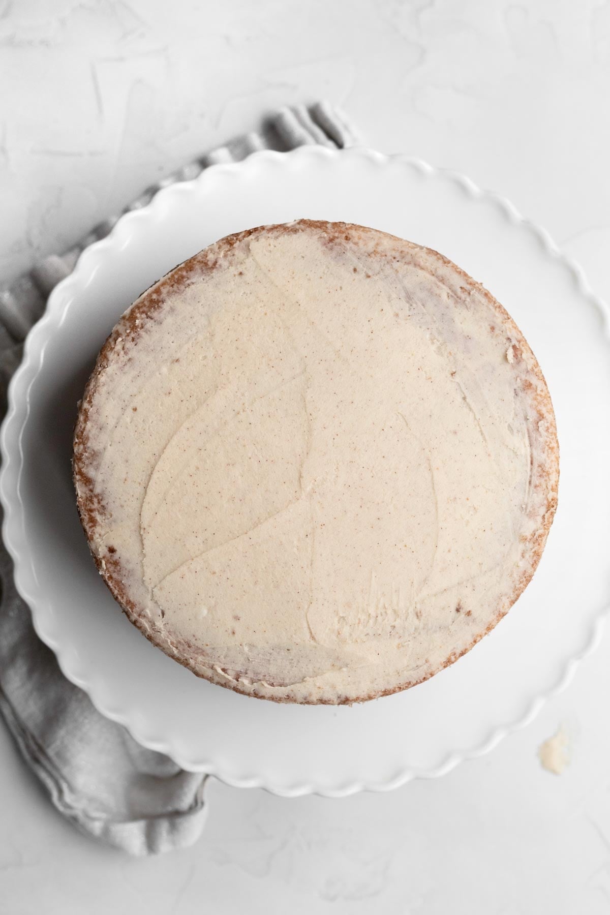 Applying a thin layer of brown sugar frosting to the gluten free apple cake.