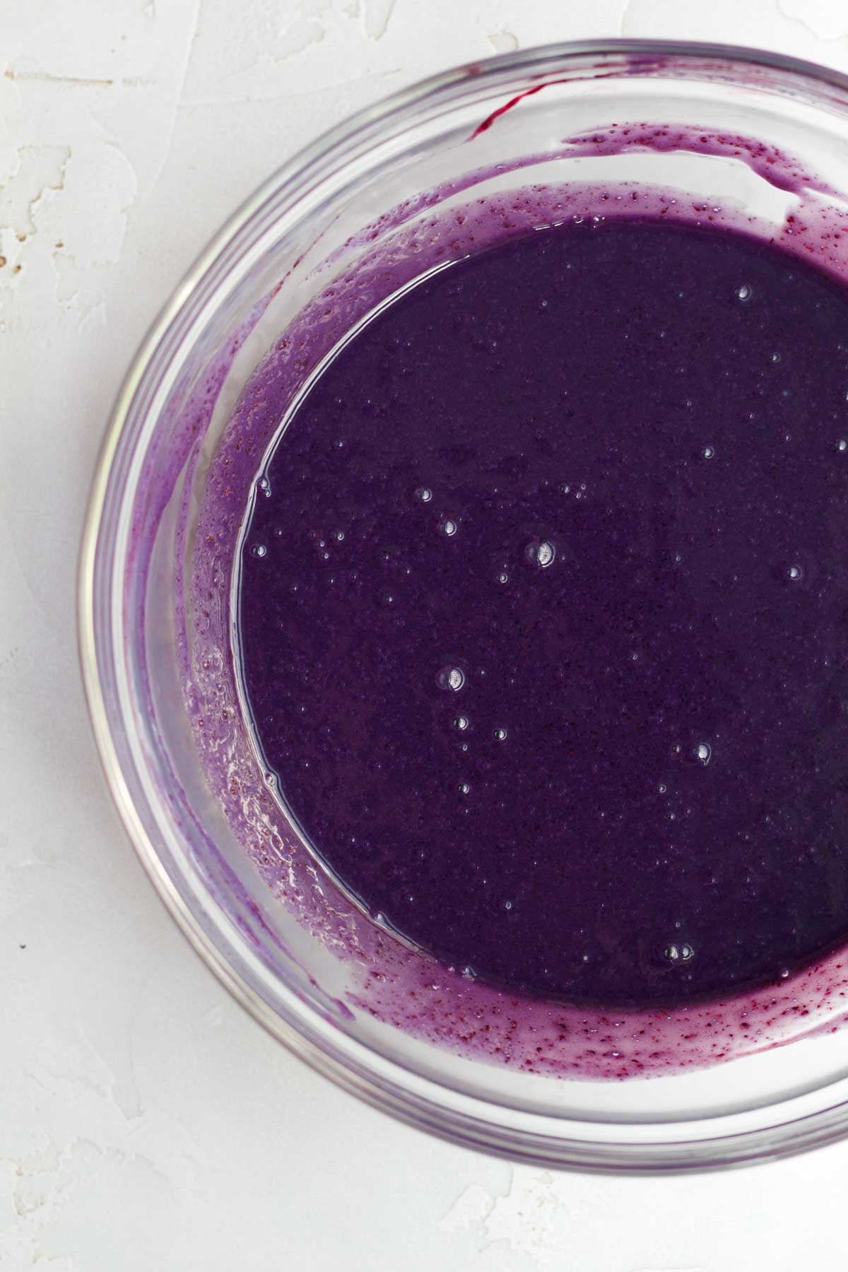 Deep violet blueberry liquid in a lgass bowl.
