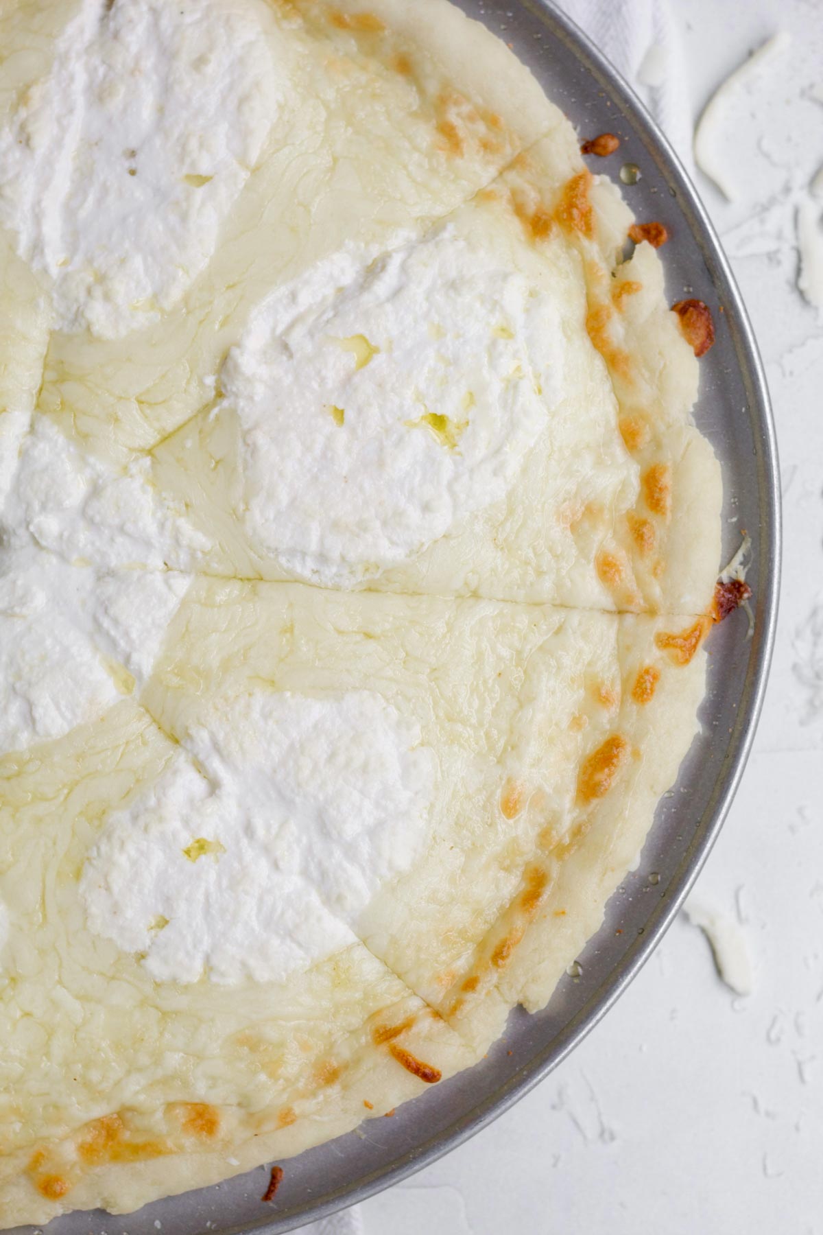 Triangular slices of pizza bianca (white pizza) on a metal pizza pan.