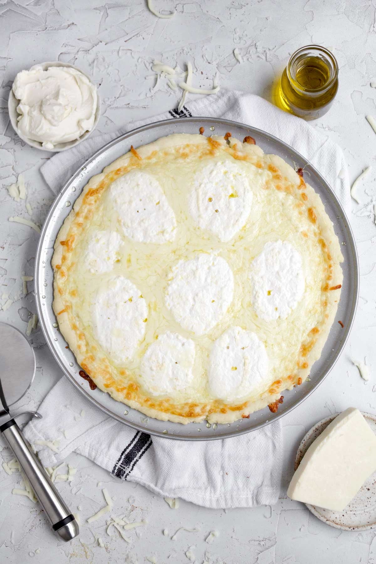 Beautifully baked pizza bianca with warm ricotta and melted mozzarella cheese .