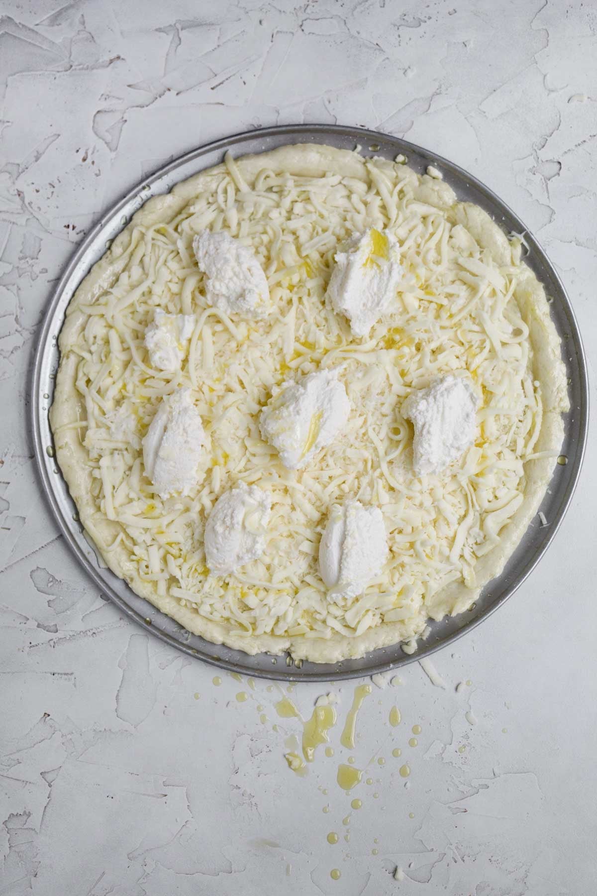Olive oil drizzled on the pizza and brushed on the crust's edges.