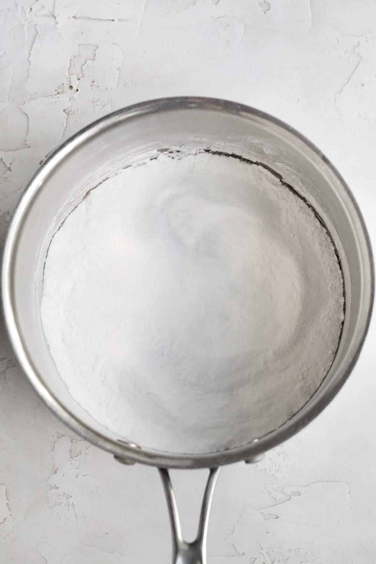 A saucepan with cornstarch, sugar and salt in it.