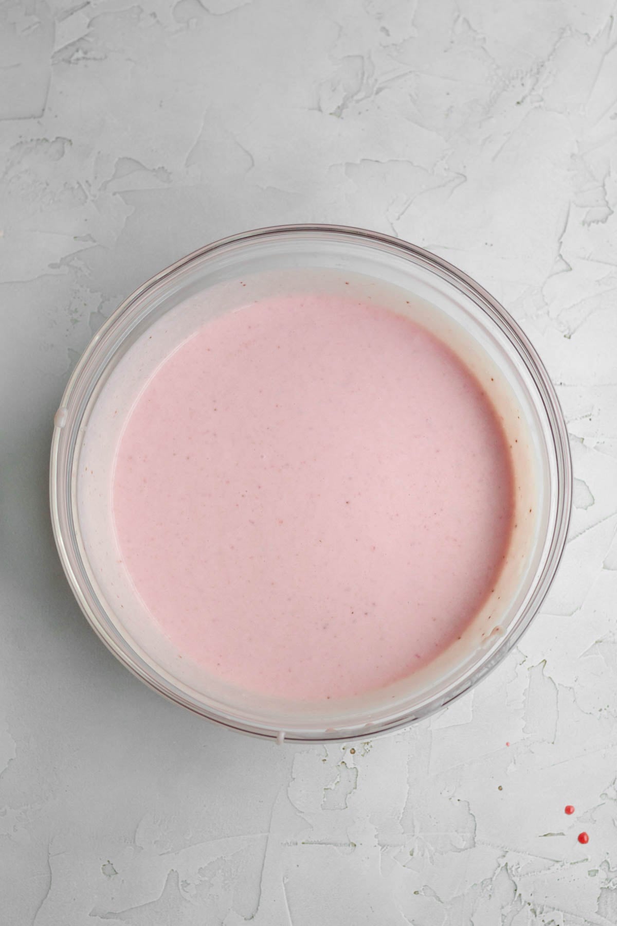 Blended strawberry liquid with milk in a glass bowl.