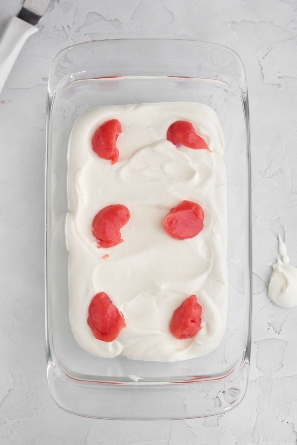 Six dollops of strawberry curd on top of the vanilla ice cream layer.