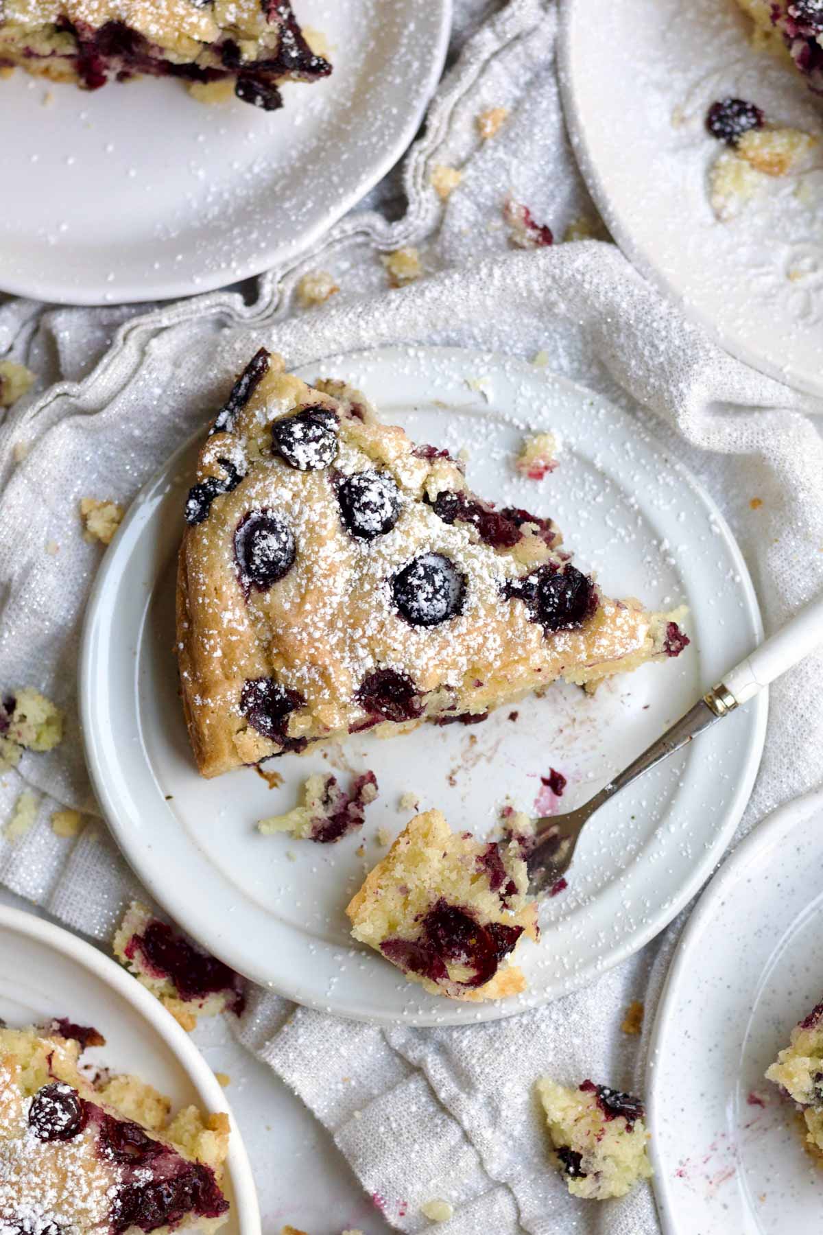 A slice of delicious gluten free olive oil cake with a fork holding a perfect bite.