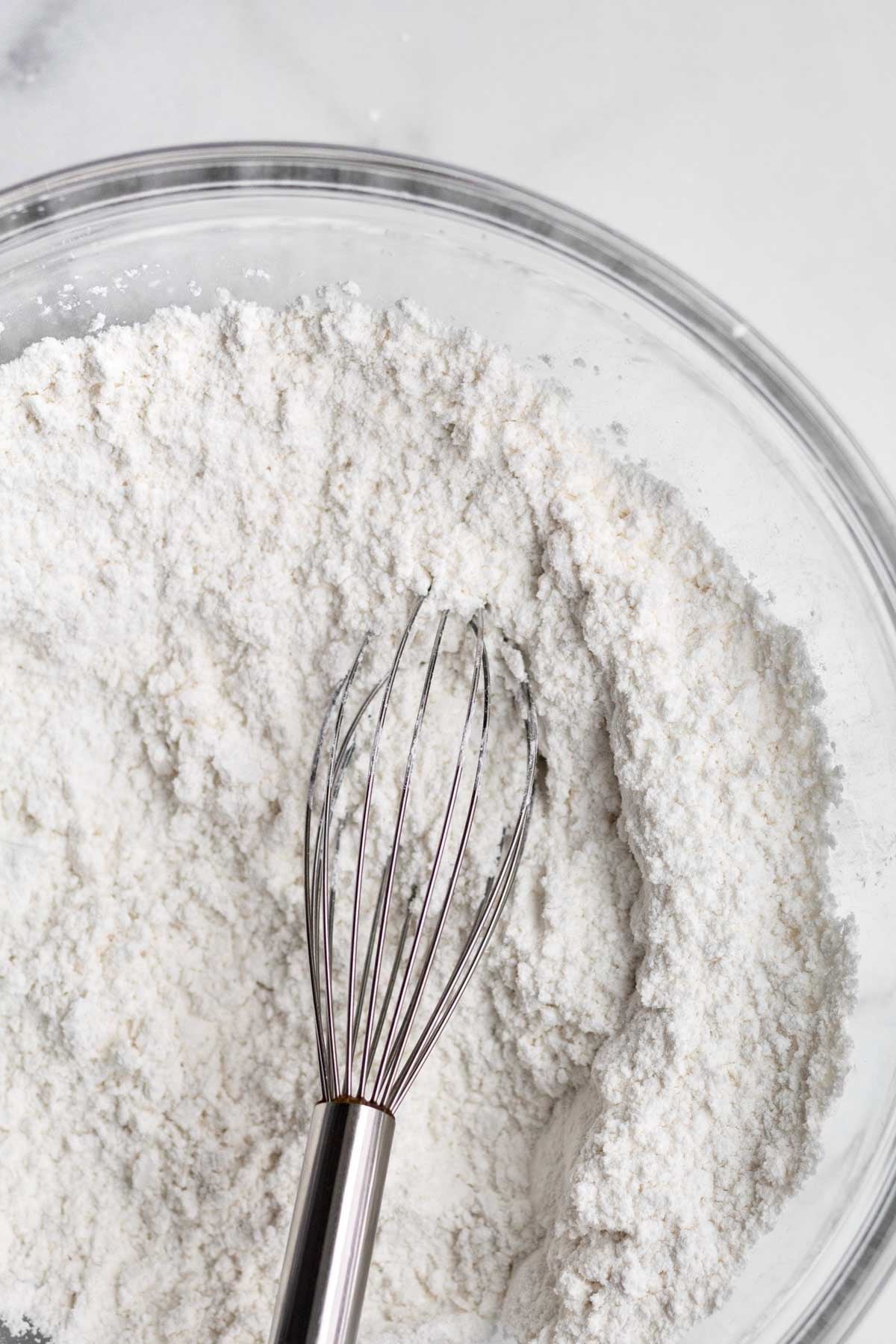 A whisk with the white dry ingredients.