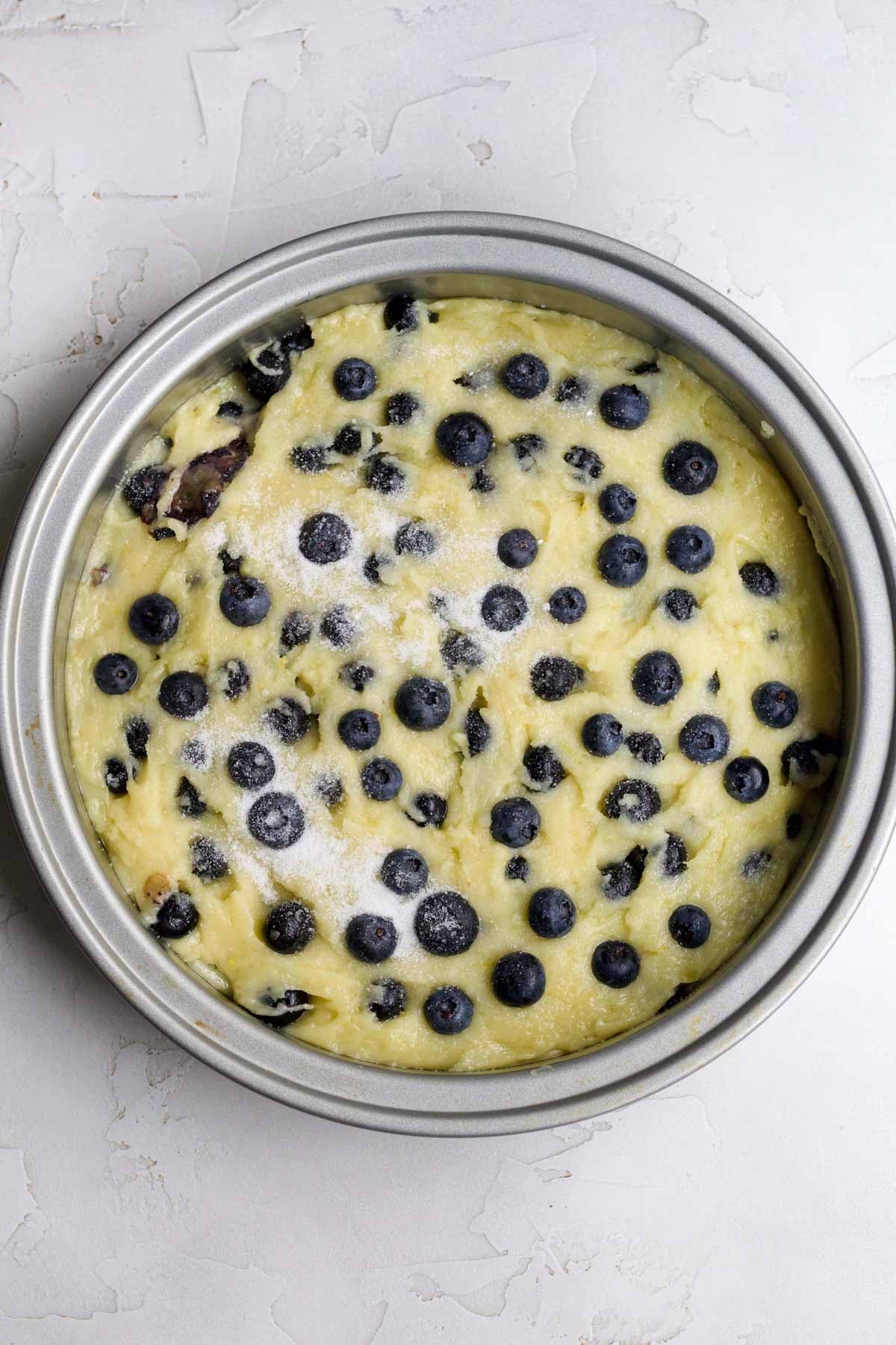 Filling a cake pan with the gluten free olive oil cake batter.