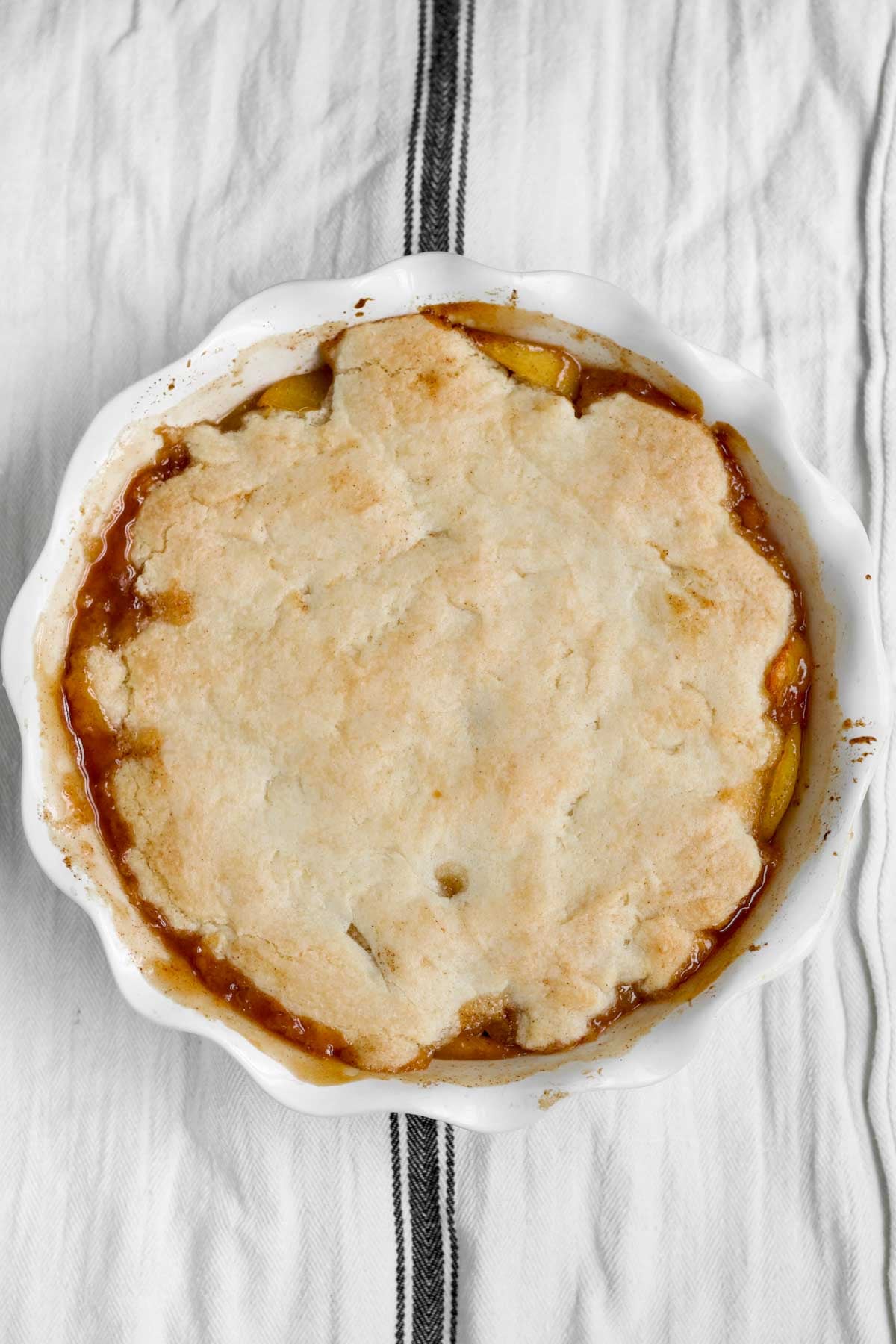 Fresh-baked, golden-brown gluten free peach cobbler right out of the oven.