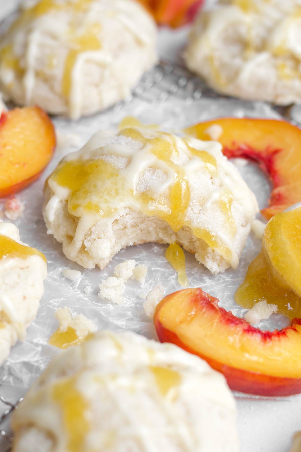 Soft gluten-free peach cookie with a bite through the sugary peach glaze and strained peaches.