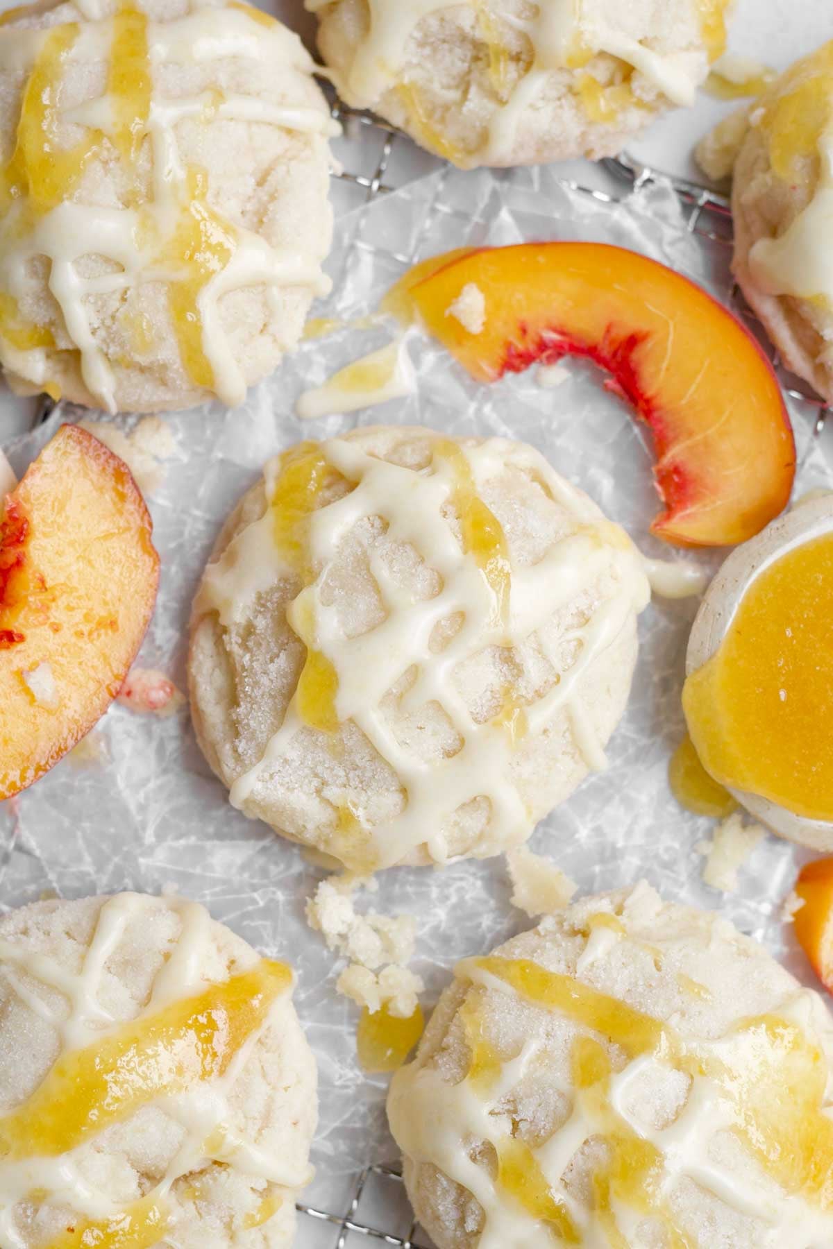 Peach cookies with sweet peach drizzle icing and liquid on wax paper.