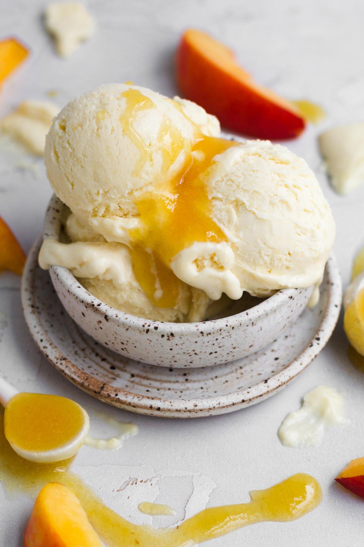 A sweet three scoop sundae of peach ice cream drizzled in sugary peach syrup.
