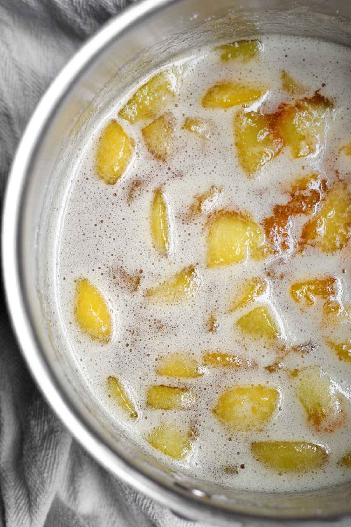 A simmering pan of peaches, sugar and salt.