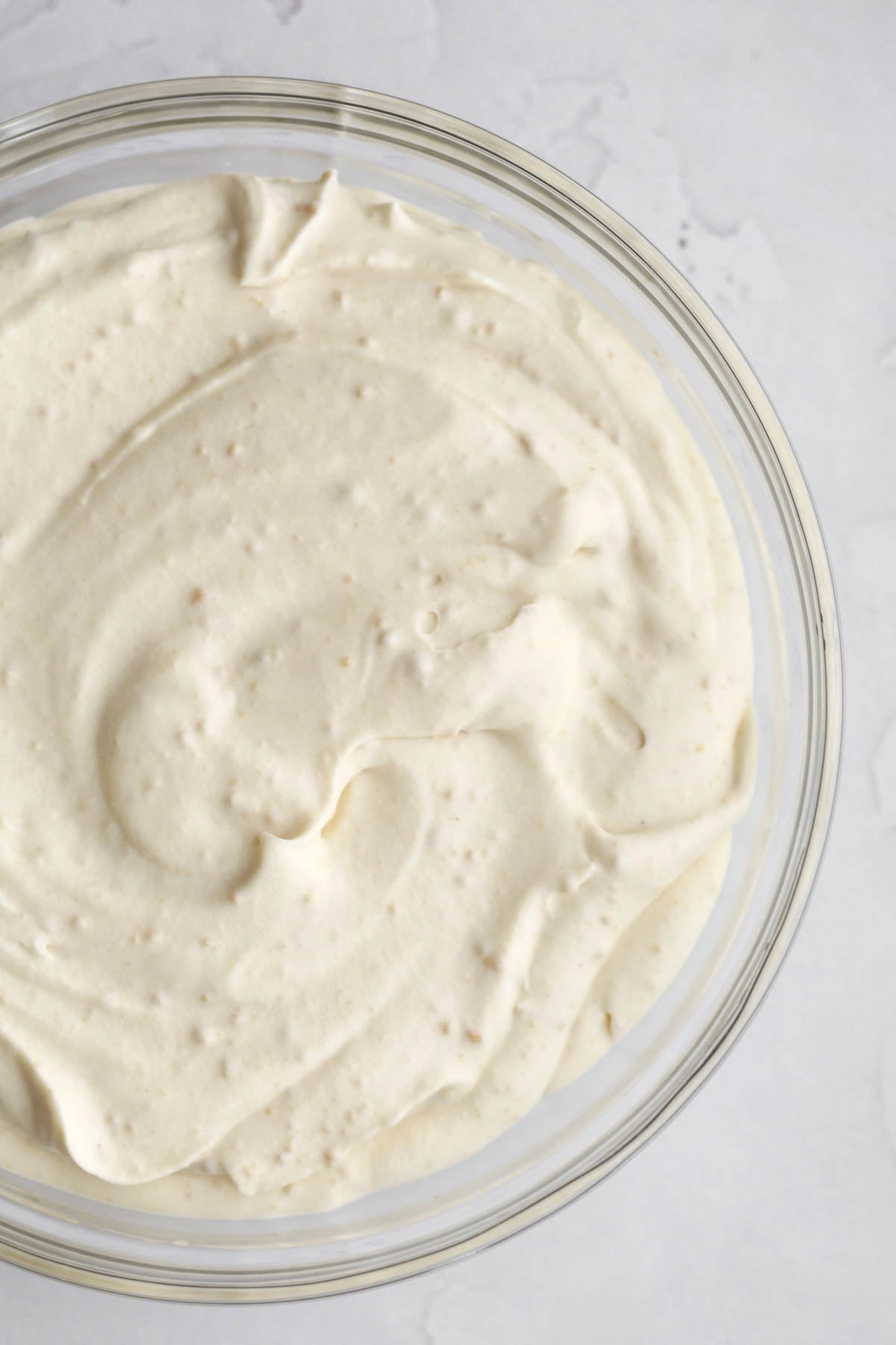 Mixing in the sweetened condensed milk mixture into an ice cream base.