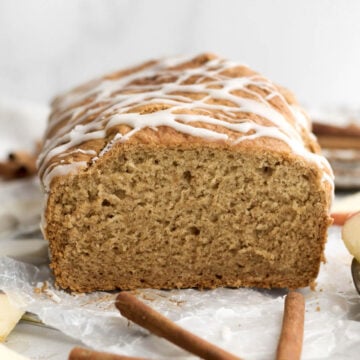 Gluten-free apple loaf cake drizzled with apple glaze sliced open revealing its soft crumbly interior.