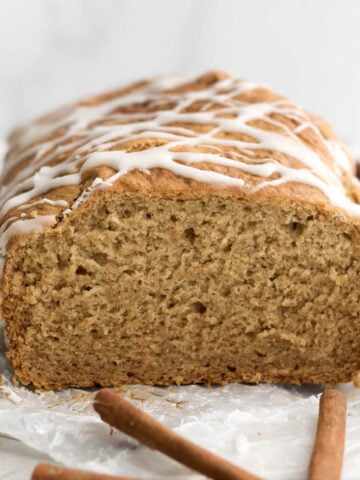 Gluten-free apple loaf cake drizzled with apple glaze sliced open revealing its soft crumbly interior.