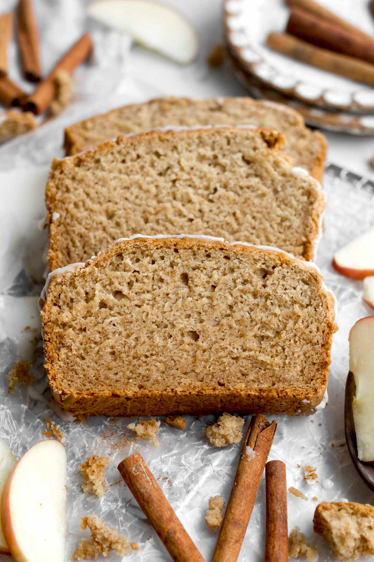 Three perfect slices of tender apple loaf cake resting on wax paper.