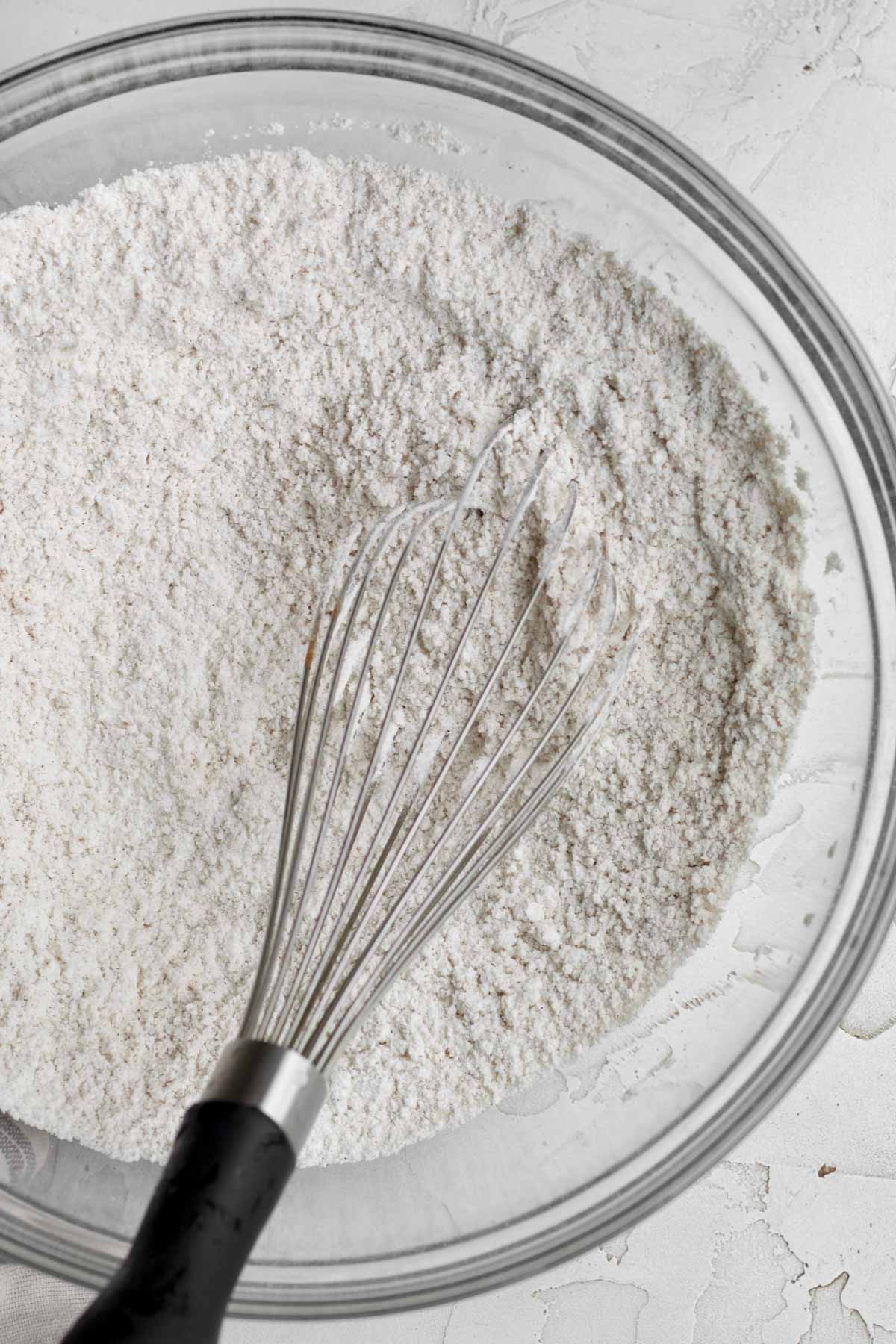 A whisk with the white dry ingredients.