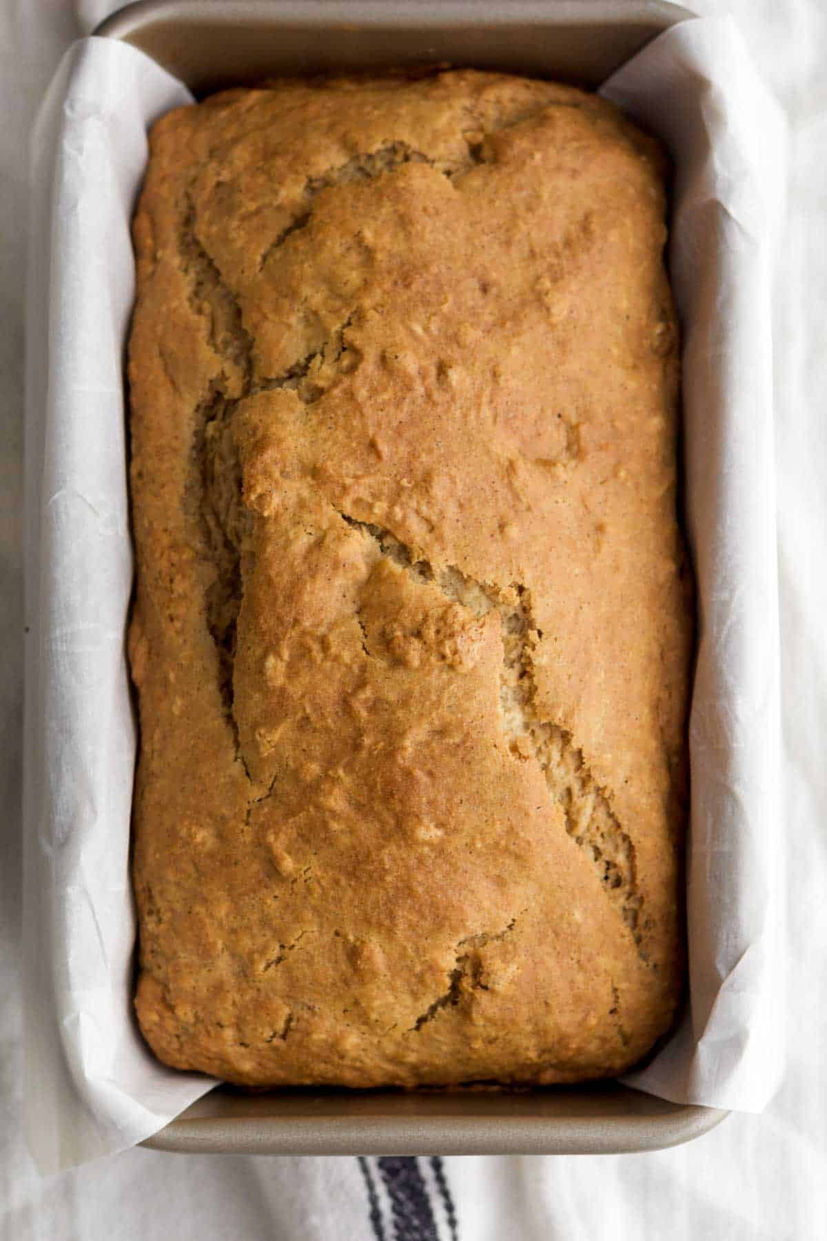 Fresh-baked apple loaf cake risen and golden brown in the loaf pan.