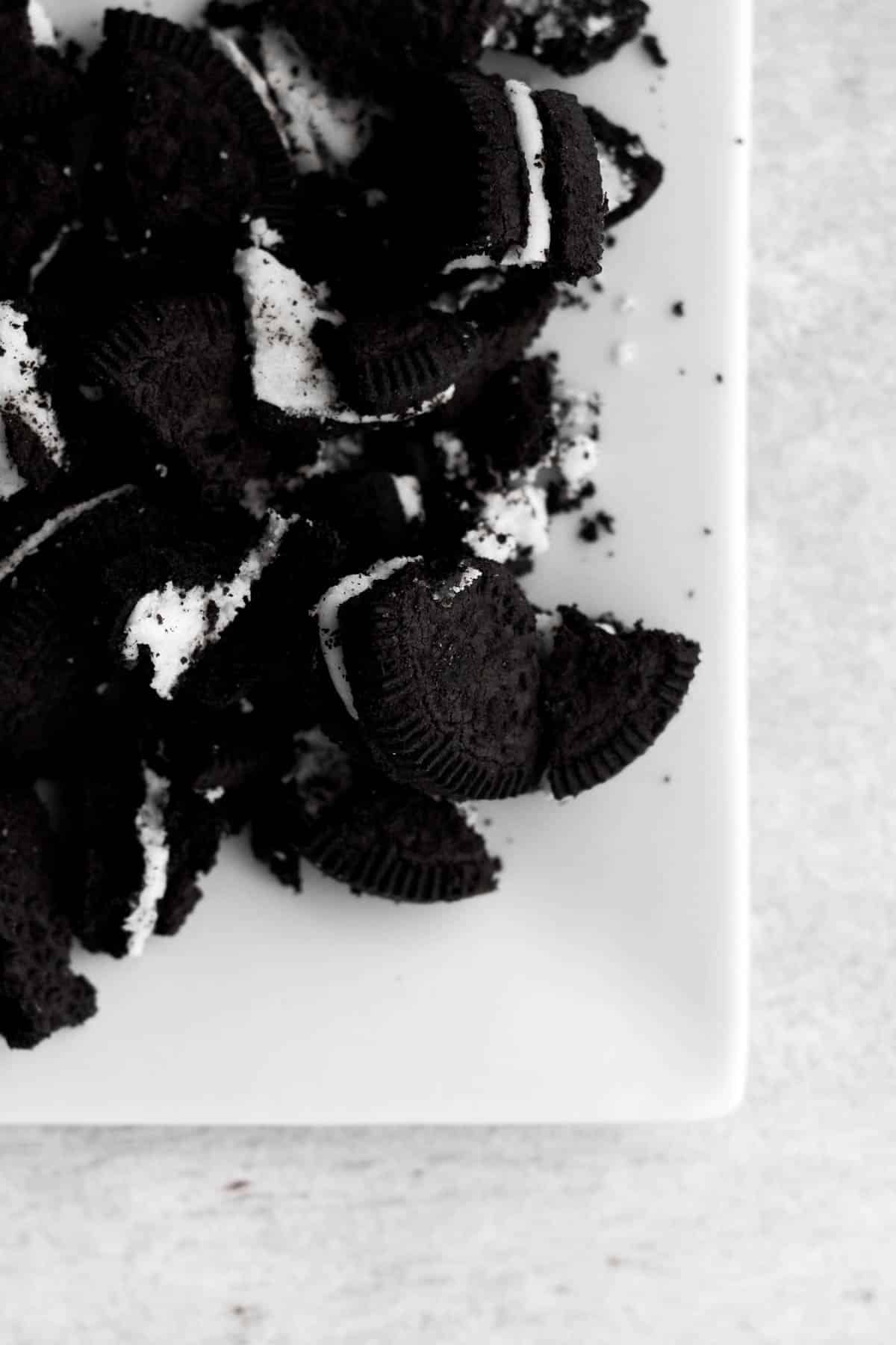 Broken sandwich cookies on a plate.