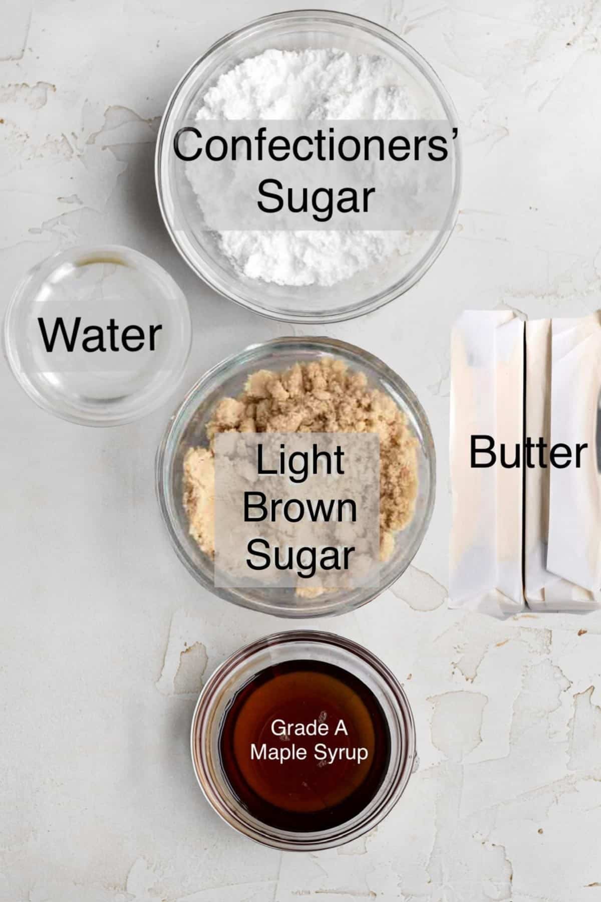 Maple frosting ingredients in separate bowls: confectioners' sugar, water, light brown sugar, butter and grade a maple syrup.